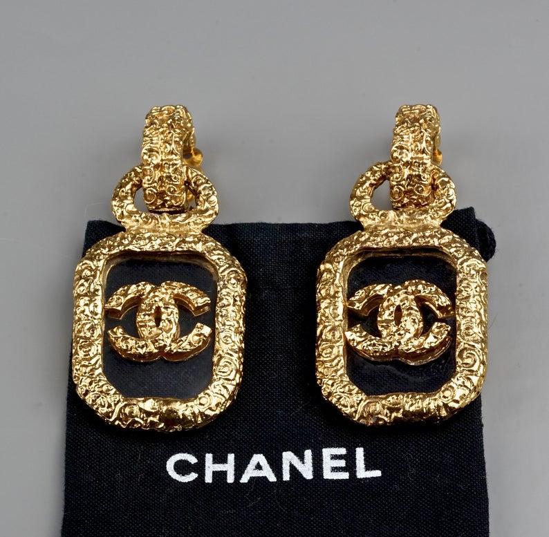 Vintage CHANEL Baroque Plexiglass Floating Logo Earrings

Measurements: 
Height: 2.64 inches (6.7 cm)
Width: 1.26 inches (3.2 cm)
Weight per Earring: 28 grams

Features:
- 100% Authentic CHANEL.
- Highly etched Rococo pattern.
- Top part with