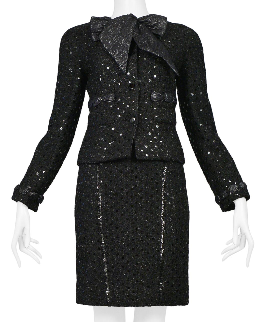 Vintage Chanel black boucle skirt suit ensemble. Jacket is embellished with sequins and woven taffeta ribbon detail. Quilted black taffeta crossback tank is paired with high waisted boucle skirt w/ black sequin detail throughout. This ensemble is a