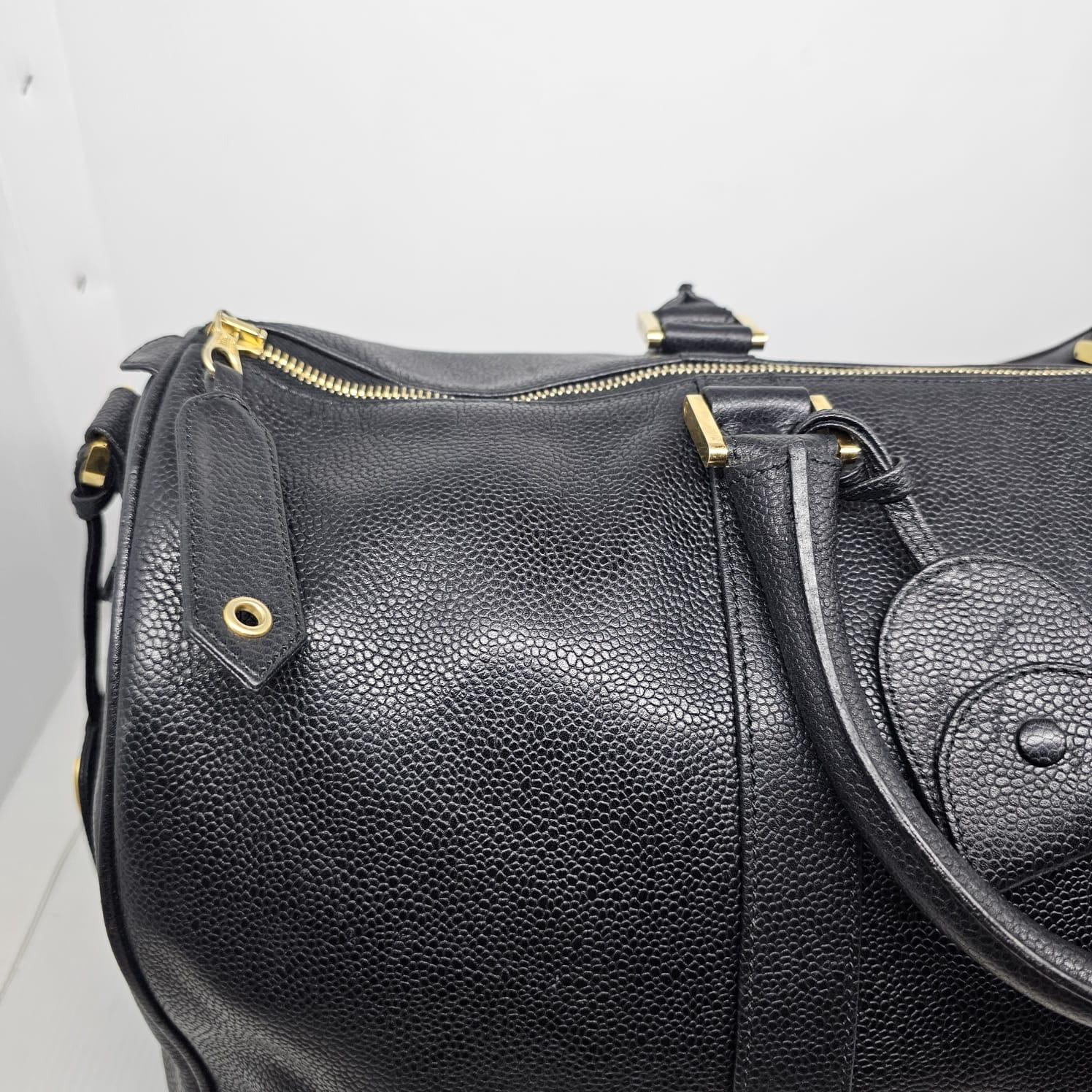 Vintage Chanel caviar duffle bag in black leather with gold hardware. Visible scuffing and scratches throughout the leather surface. Leather has slightly suppled. Item is missing its long strap. Comes with its holo intact and leather tag only.