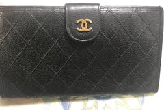 Vintage CHANEL black caviar leather wallet with stitches and gold tone CC motif.