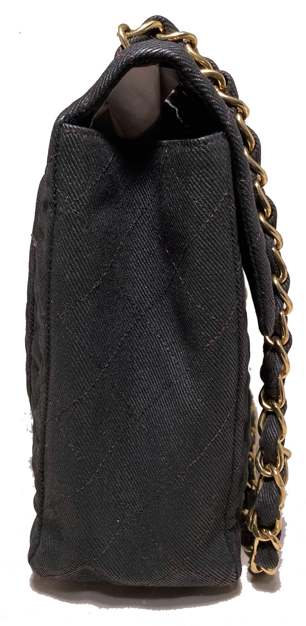 Chanel Black Denim Maxi Classic Flap Shoulder Bag in very good condition. Quilted black denim exterior trimmed with gold hardware. Front CC logo twist closure opens via single flap to a black leather interior with one slit and one zipped side
