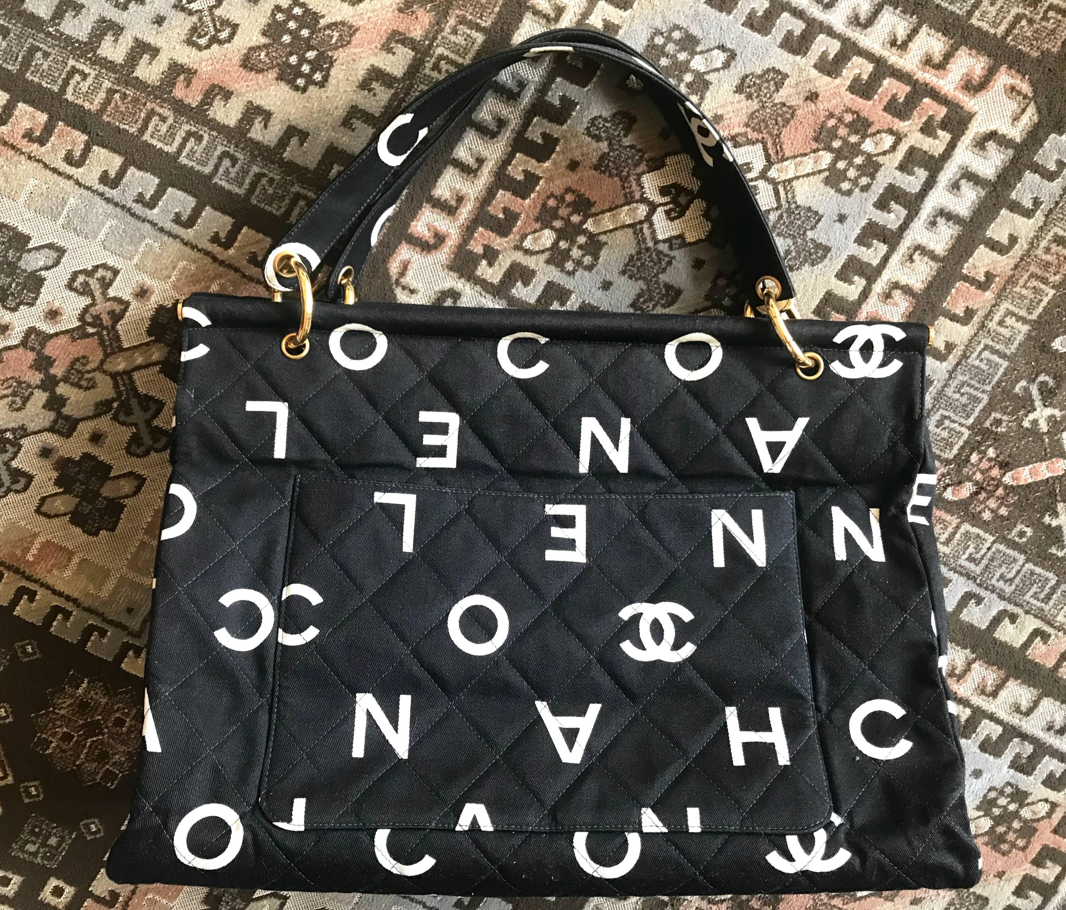 1990s. Vintage CHANEL black fabric canvas large tote bag with white Chanel CC logo print all over. Must have daily use vintage Chanel purse.

Introducing one of the most chic and mod CHANEL purses back in the 90's!
Black canvas with white logo and
