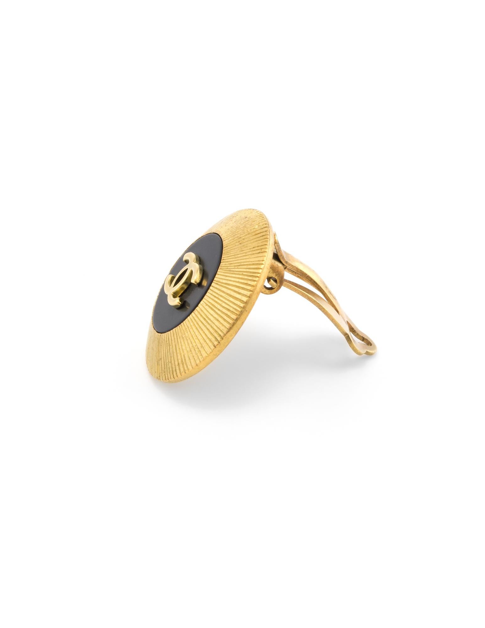 Vintage Chanel CC logo earrings crafted in yellow gold tone, circa 1995. 

The earrings feature a textured outer design with a black backdrop to the CC logo in the center. The earrings feature hinged clip backings for non-pierced or pierced