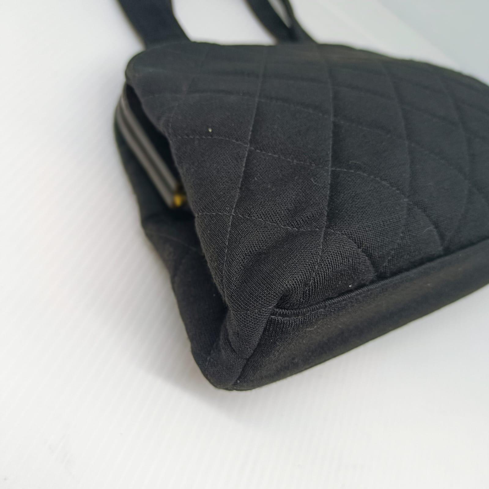 Classic vintage chanel kisslock purse in black jersey with gold hardware. Overall in good vintage condition with minor creasing on the exterior body. No significant rubbing on the corners. Visible scratch marks throughout the mouth of the leather
