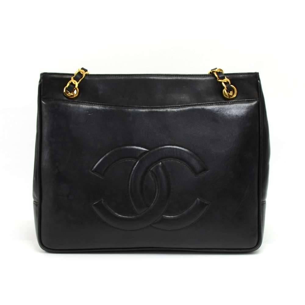 Vintage Chanel tote in black lambskin leather. It has 1 flap pocket with large CC twist lock in front and a slip pocket on the back with a large debossed and stitched CC logo. Main access is secured with 2 magnetic buttons. Inside has black leather