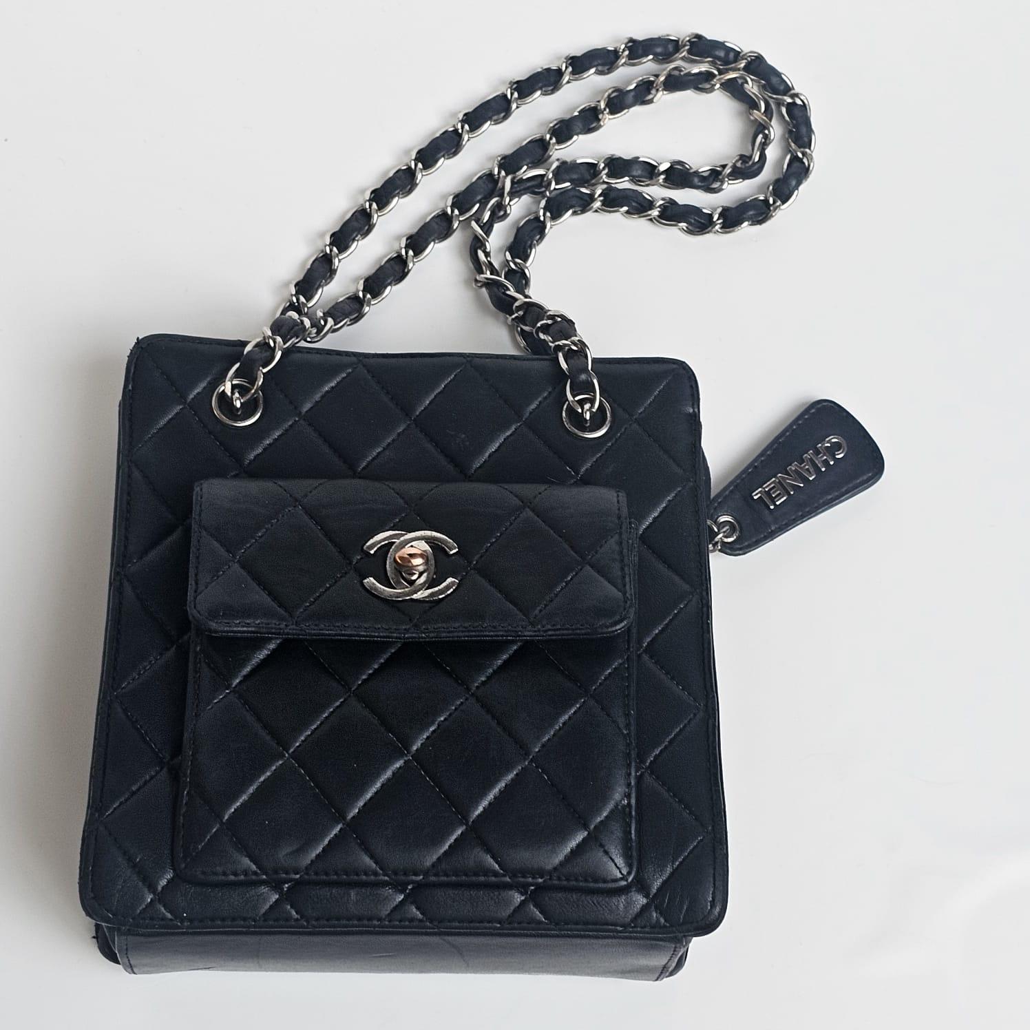 Schwarze Mini-Ketten-Tasche im Vintage-Stil mit silberner Hardware. In abgenutztem Zustand. Leichtes Austrocknen des Leders und Faltenbildung überall. Sichtbare Kratzer und Abschürfungen an den Ecken. Anlaufen vor allem auf den Drehverschluss