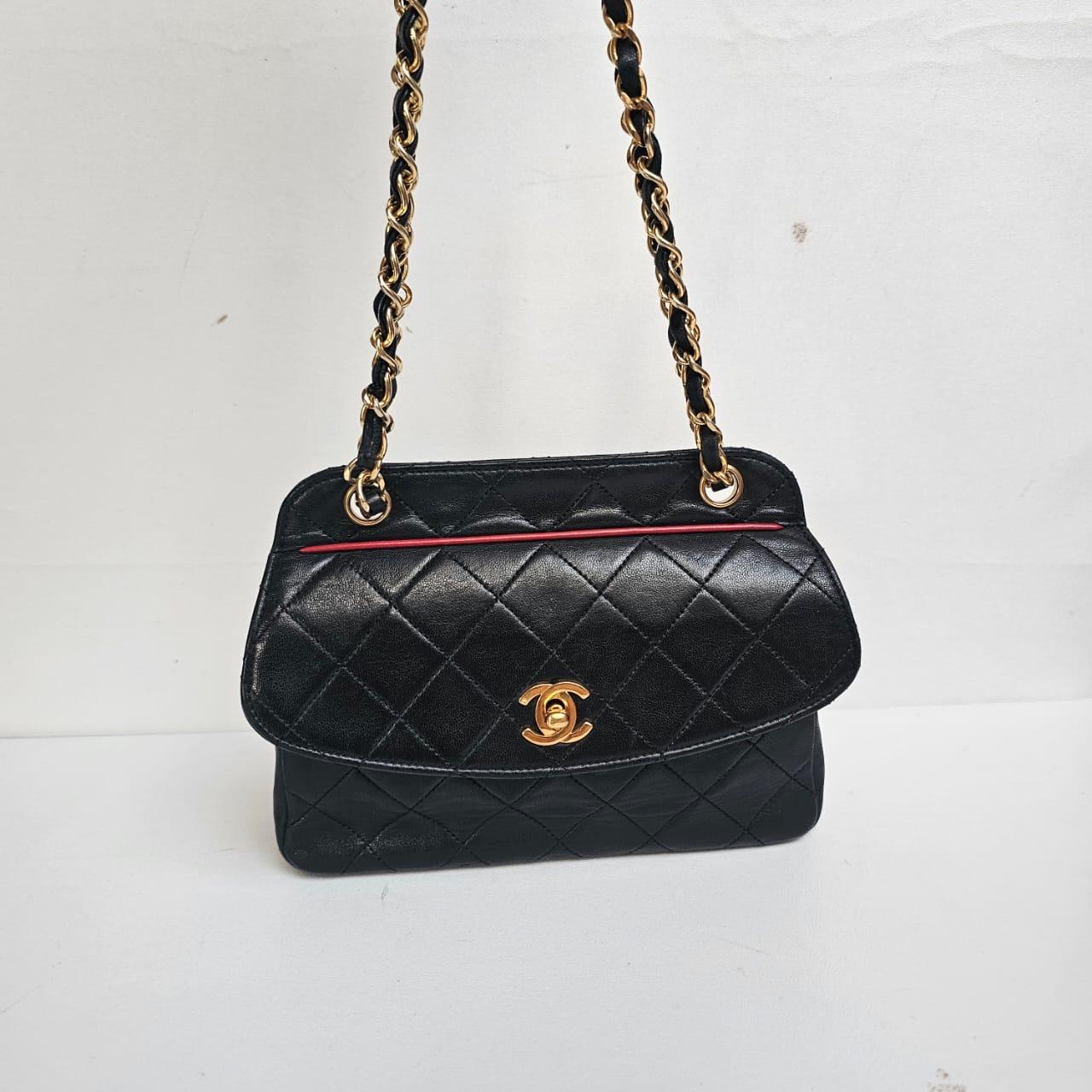 Mini vintage Chanel in black lambskin with gold hardware. Very cute and versatile piece. Can be worn as shoulder and crossbody. Faint scratching and scuffs due to the nature of the leather. Light creasing on the leather. Comes with its matching flat
