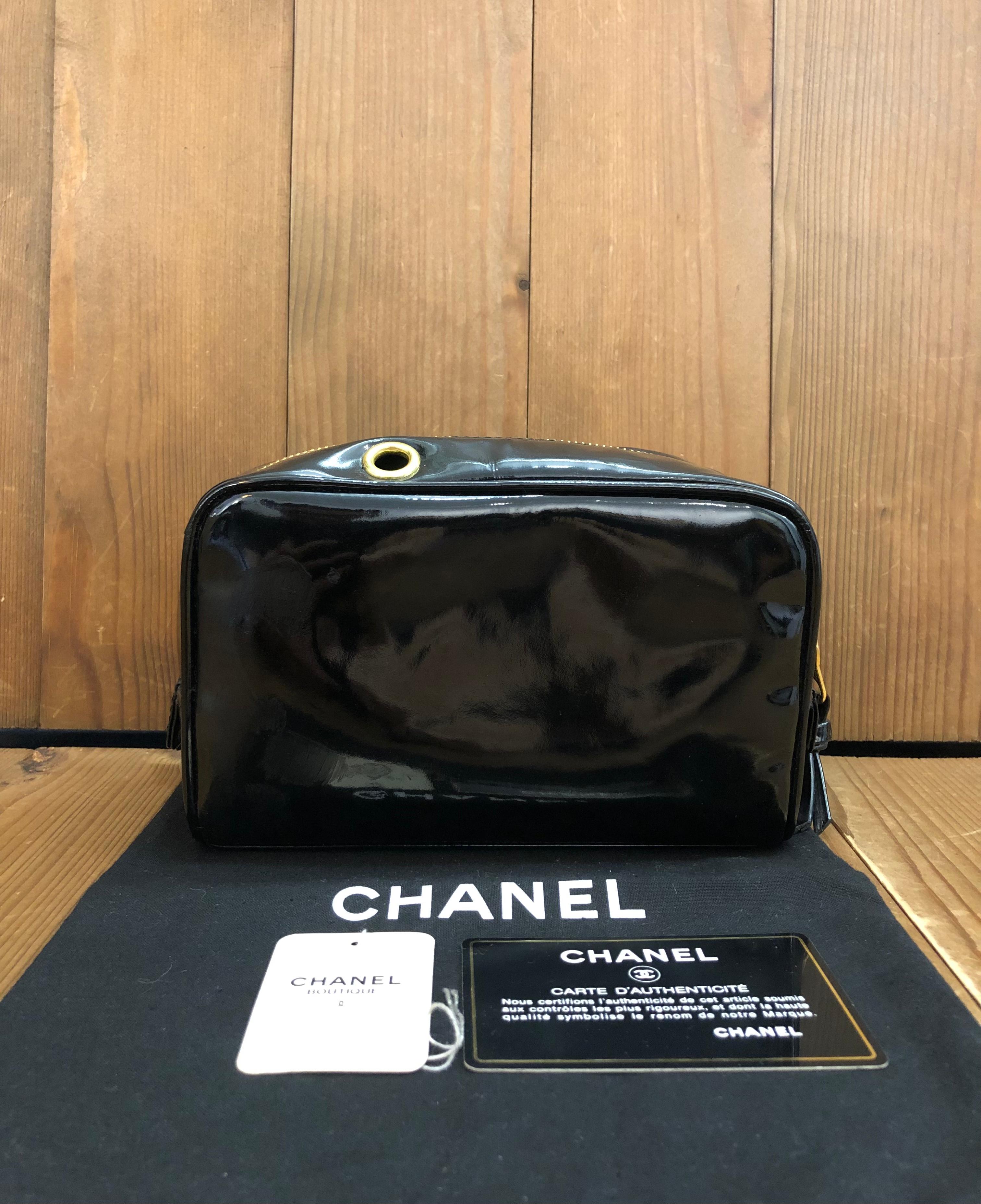 This vintage CHANEL Cosmetic Pouch Clutch Bag is crafted of black patent leather featuring gold toned hardware. Top zipper closure opens to a lambkin interior in black featuring two zippered pockets. Made in Italy. Measures approximately 7 x 3 x 4.5