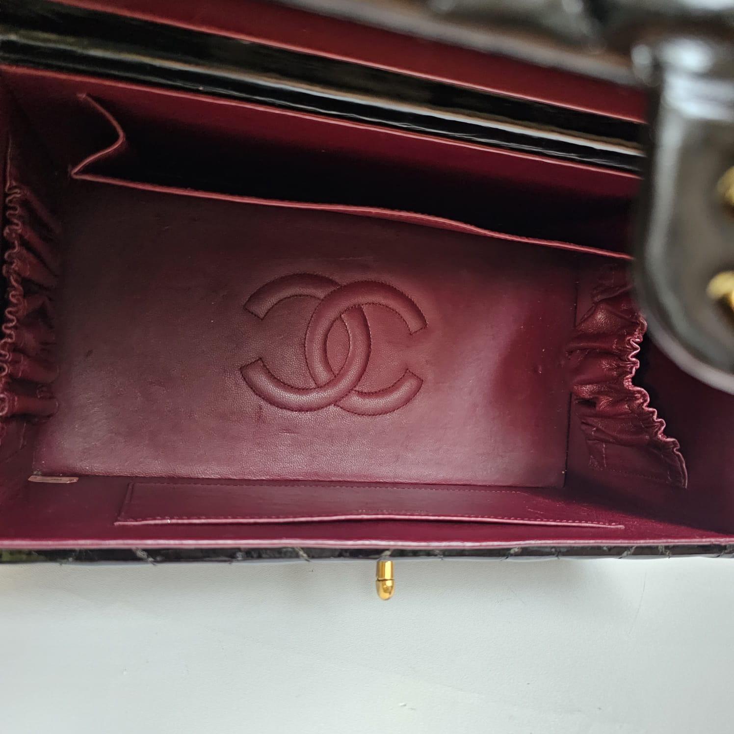 Rare vintage patent vanity box in black with gold hardware. Rare collectors item. Overall still in great vintage condition with minor marks due to storage. Faint clouding on the patent surface. Handles has slightly bent due to pressure during