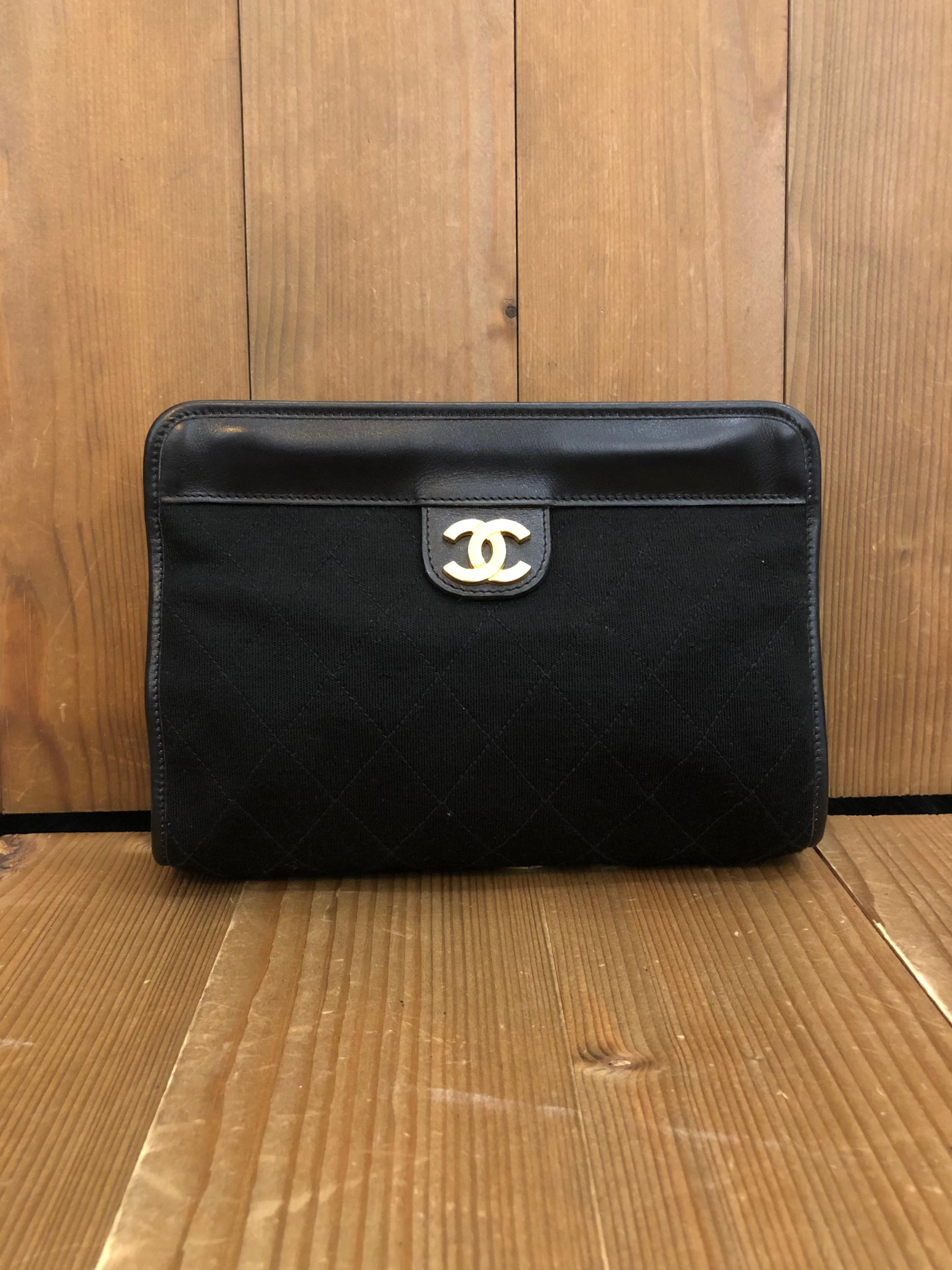This 1980s vintage CHANEL clutch bag is crafted of diamond quilted jersey in black and gold toned hardware. Top spring closure opens to a lambskin leather interior in burgundy. Made in France. Measures approximately 8.25 x 5.5 x 2 inches. This