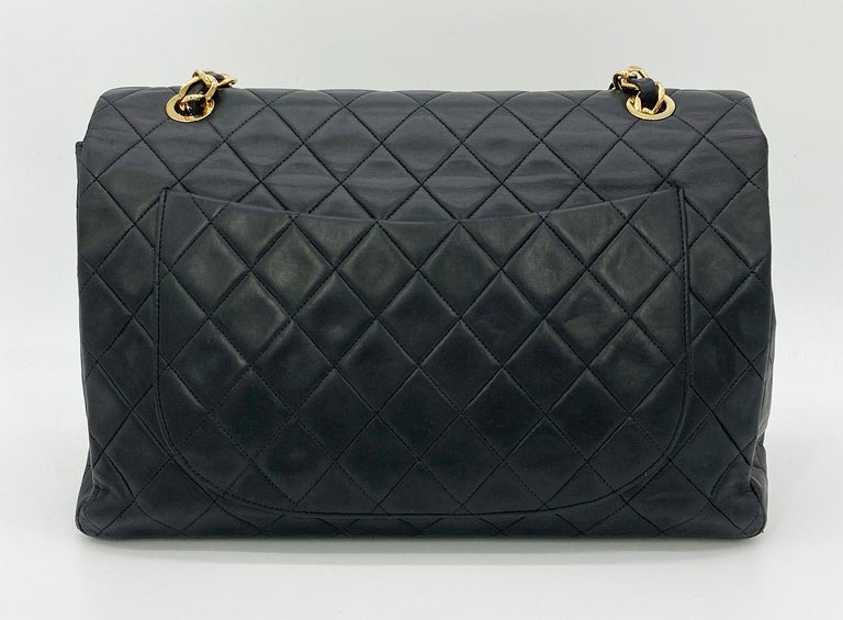 Vintage Chanel Black Quilted Lambskin Maxi Classic Flap in good condition. Black quilted lambskin exterior trimmed with gold hardware and woven chain and leather shoulder strap. signature CC logo twist closure opens via single flap to a maroon