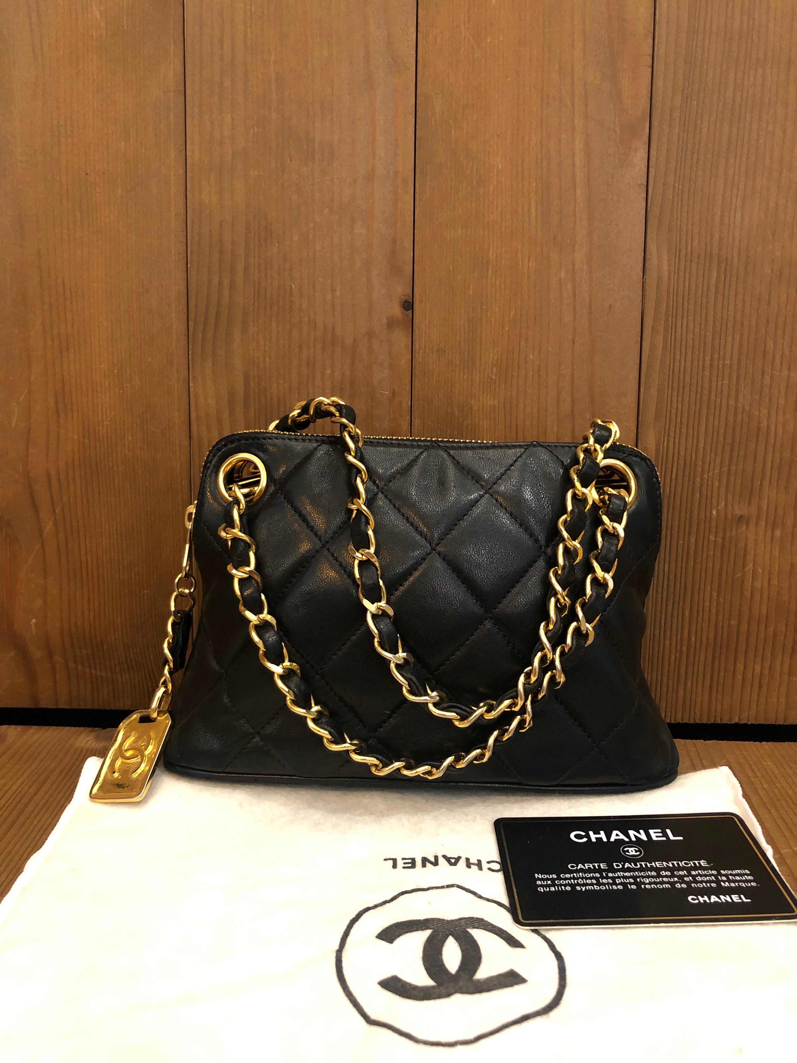 This vintage Chanel mini hand bag is crafted of Chanel’s iconic diamond quilted lambskin leather in black featuring gold toned chain handles interlaced with the same leather. 1xxxxxx series. Made in Italy. Measures approximately  7.75 x 5 x 2.25
