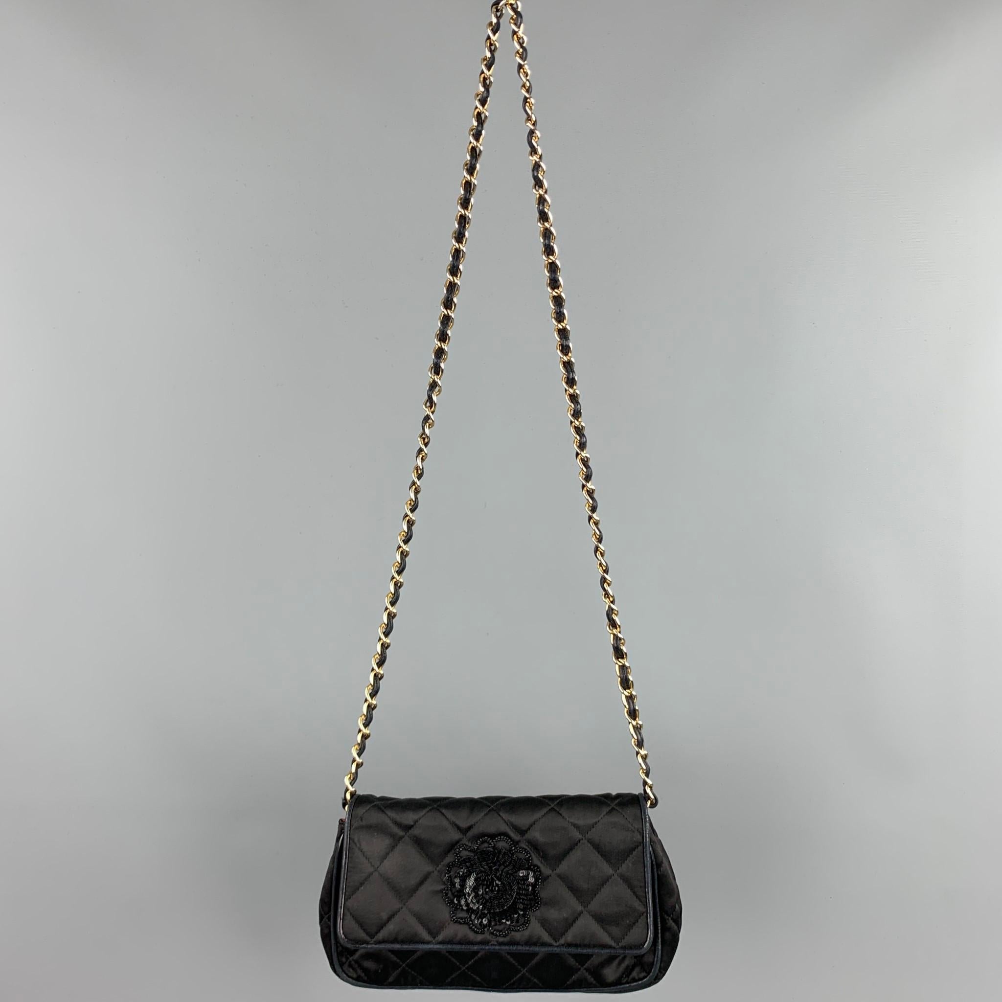Vintage CHANEL handbag comes in a black quilted nylon with a leather trim featuring a front sequined flower design, chain cross body strap, red interior, inner zipper pocket, and a snap button closure. Made in Italy.

Very Good Pre-Owned