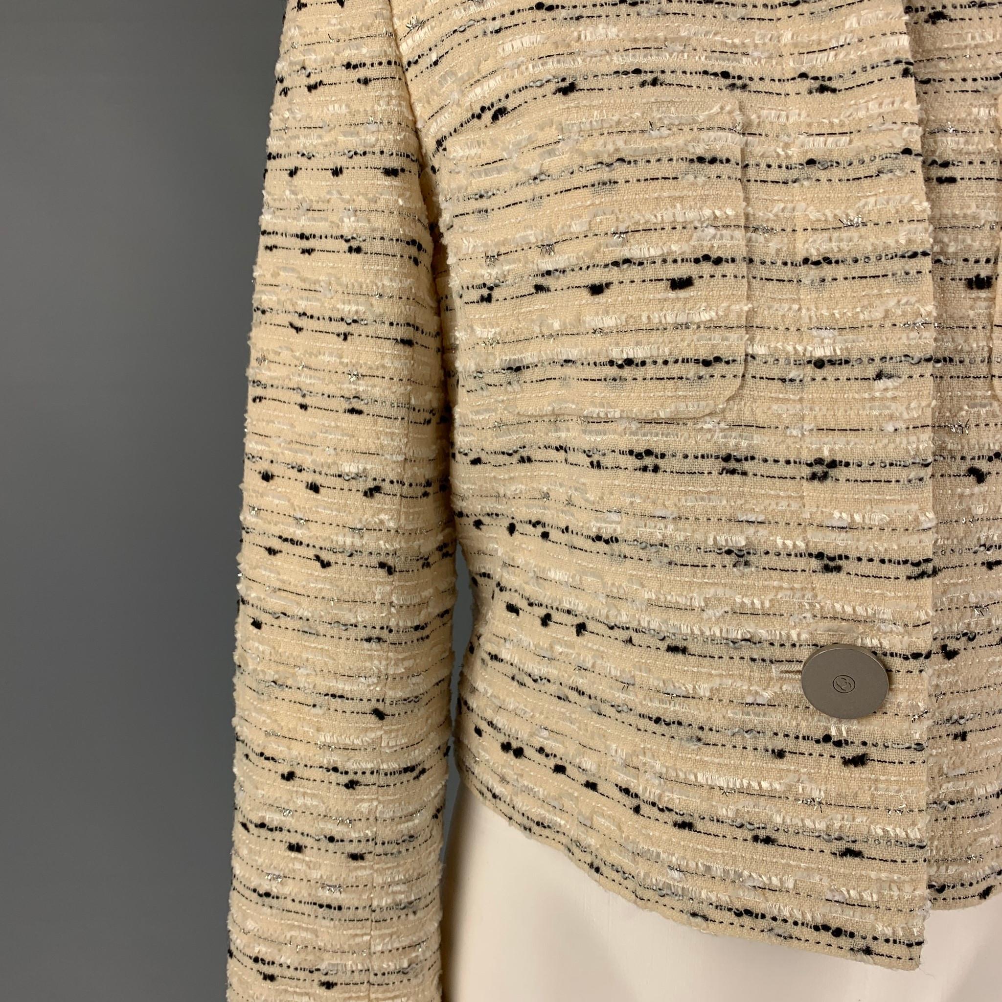 Vintage CHANEL BOUTIQUE 99C jacket comes in a cream & black boucle wool blend with a full monogram print featuring a spread collar, patch pockets, large silver tone logo detail, and a hidden placket closure. Made in France. 

Very Good Pre-Owned
