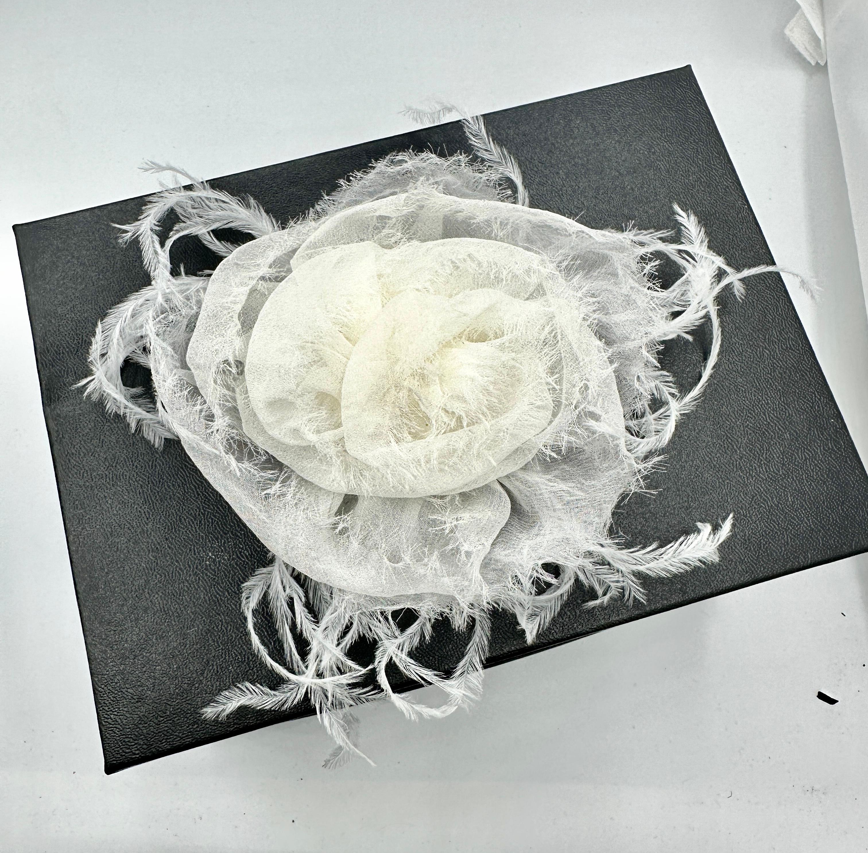 This is a fabulous vintage Chanel Caméllia Flower brooch in White Silk Crepe and Feathers.   It is an elegant vintage brooch by the House of Chanel in a rare and wonderful design.  The rare Camellia Flower is constructed with three dimensional silk
