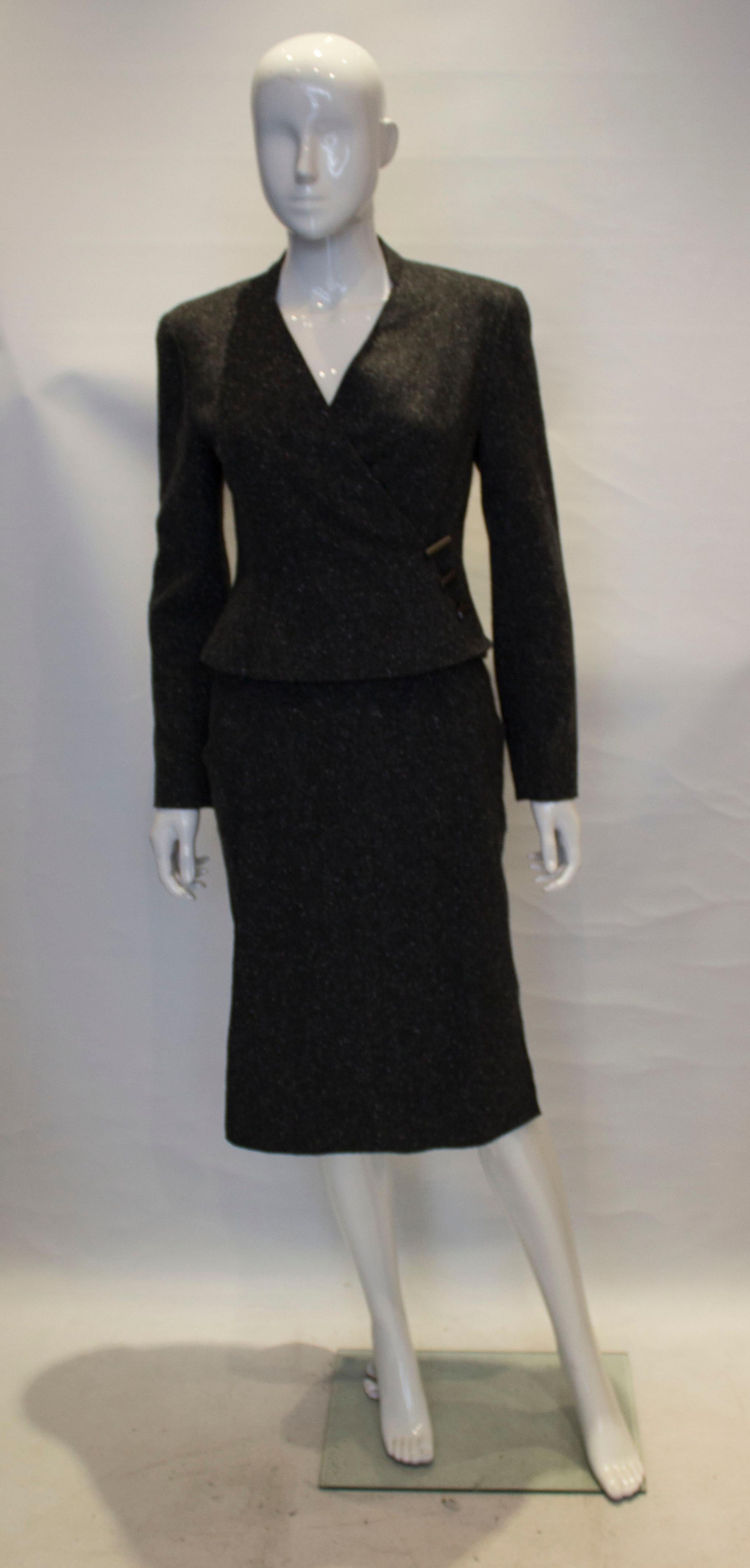 A charming and slightly unusual skirt suit by Chanel. The jacket is 100 % cashmere and lined in silk. It has a cross over v neckline and fastens with buttons and clips stamped Chanel.

The skirt is 100 % cashmere and unlined. It has a central back
