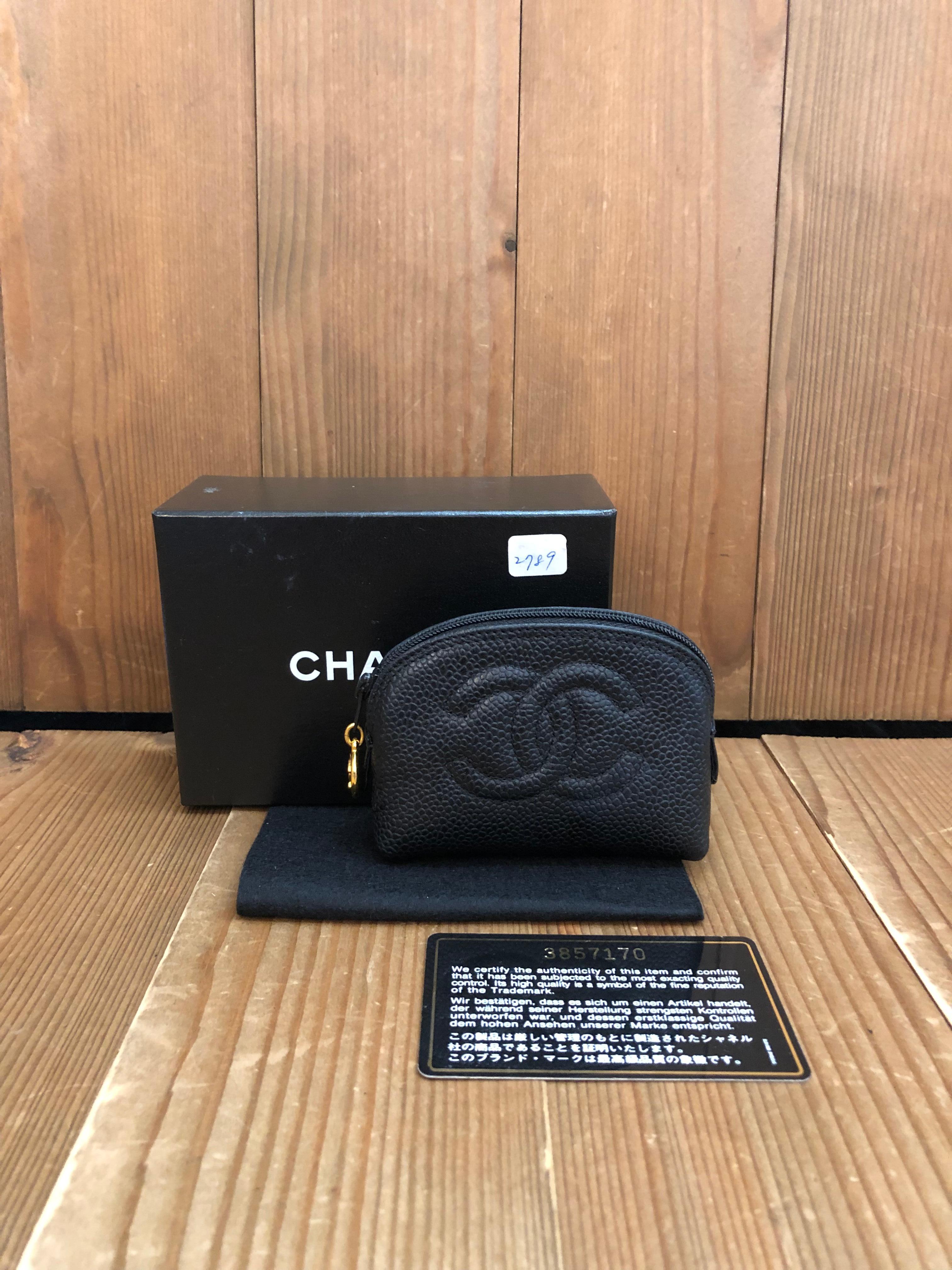 This vintage CHANEL mini pouch bag is crafted of caviar calfskin leather in black featuring gold toned hardware. Top zipper closure opens to a coated interior which has been professionally cleaned. Measures approximately 4 x 3 x 1.5 inches. Made in