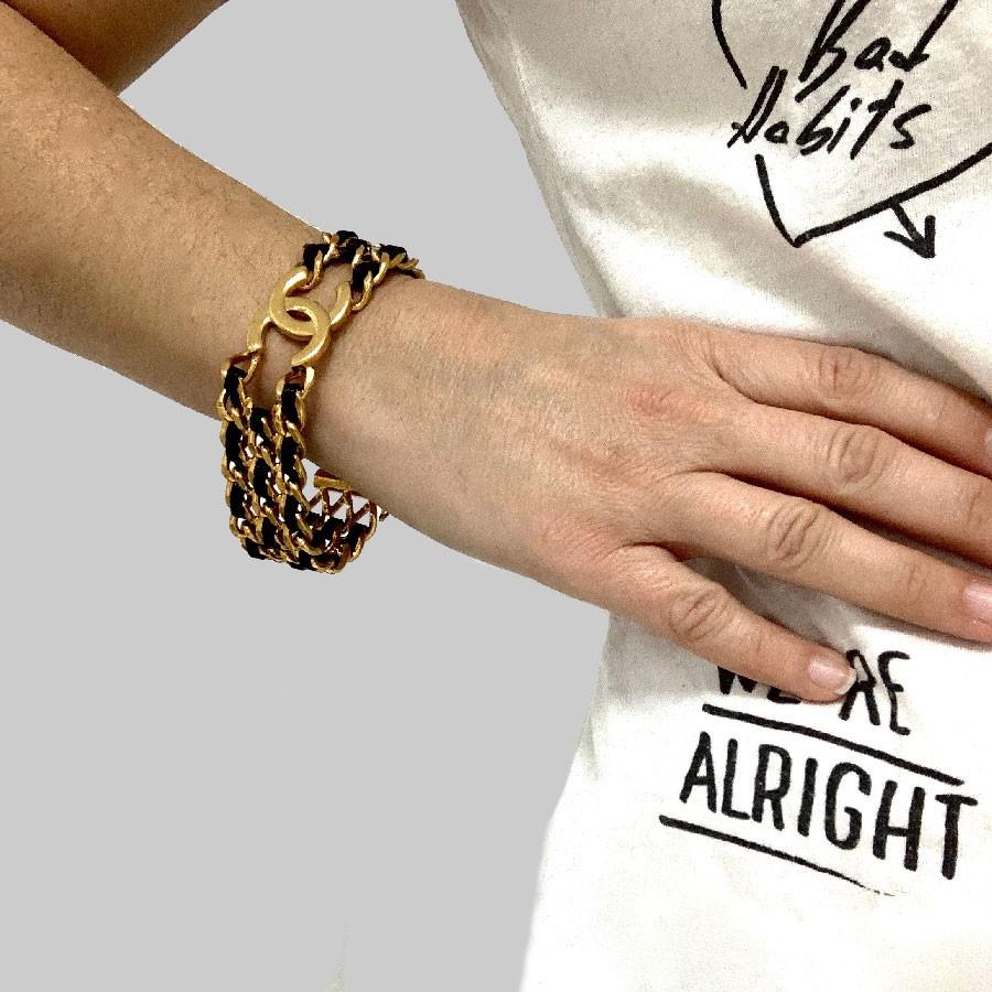 Chanel gold chain and black leather bracelet. 
Collector! Chanel bracelet made of gold plated metal chains intertwined with black lamb leather. A reminder of the famous classic timeless bags.
In the middle, a sublime CC signature in golden metal.