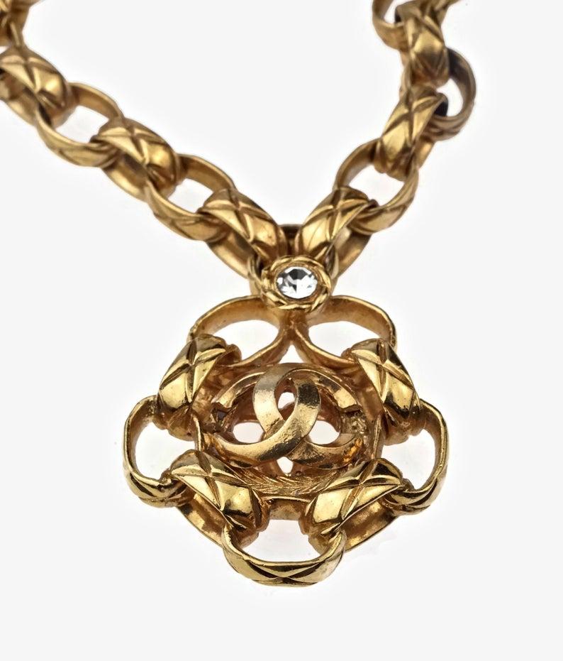Vintage CHANEL CC Logo Rhinestone Medallion Quilted Necklace

Measurements:
Height: 1.96 inches (5cm)
Wearable Length: 15.55 inches (39.5 cm)

Features:
- 100% Authentic CHANEL.
- Quilted chain and pendant with CC logo and rhinestone at the centre.