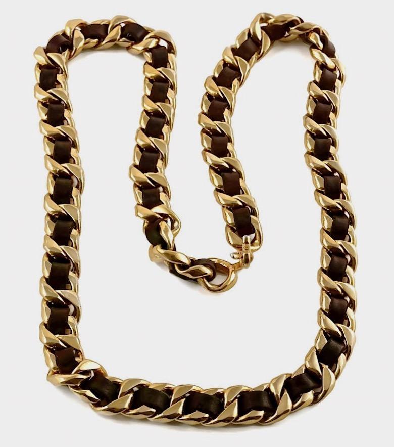 Vintage CHANEL Classic Chain Brown Leather Necklace Belt

Measurements:
Height: 6/8 inch (1.90 cm)
Length: 41 2/8 inches (104.77 cm)

Features:
- 100% Authentic CHANEL.
- 2 swags of chain entwined with brown leather.
- Signed CHANEL CC.
- Adjustable