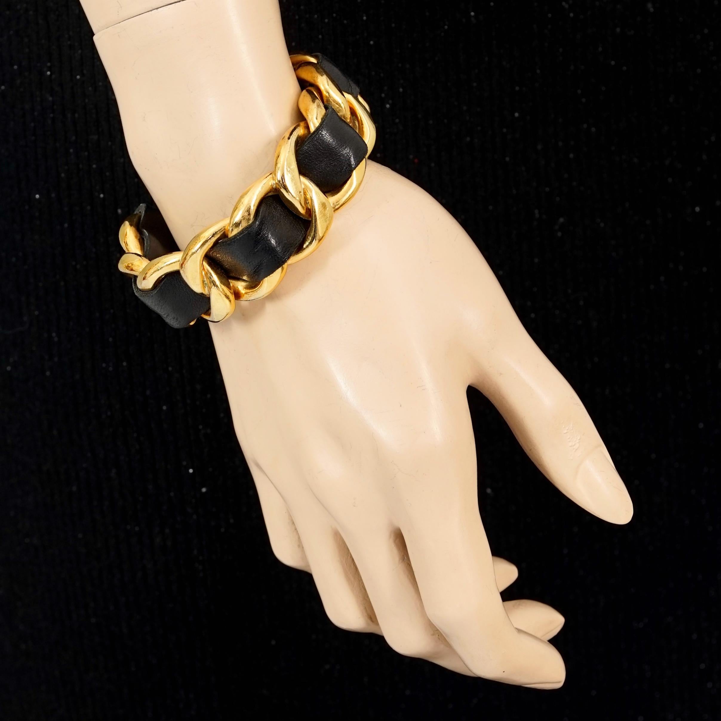 Vintage CHANEL Classic Gold Chain and Leather Bangle Bracelet

Measurements:
Height: 0.90 inch (2.3 cm)
Inside Circumference: 6.81 inches (17.3 cm) opening included

Features:
- 100% Authentic CHANEL.
- Rigid and chunky chain and black leather
