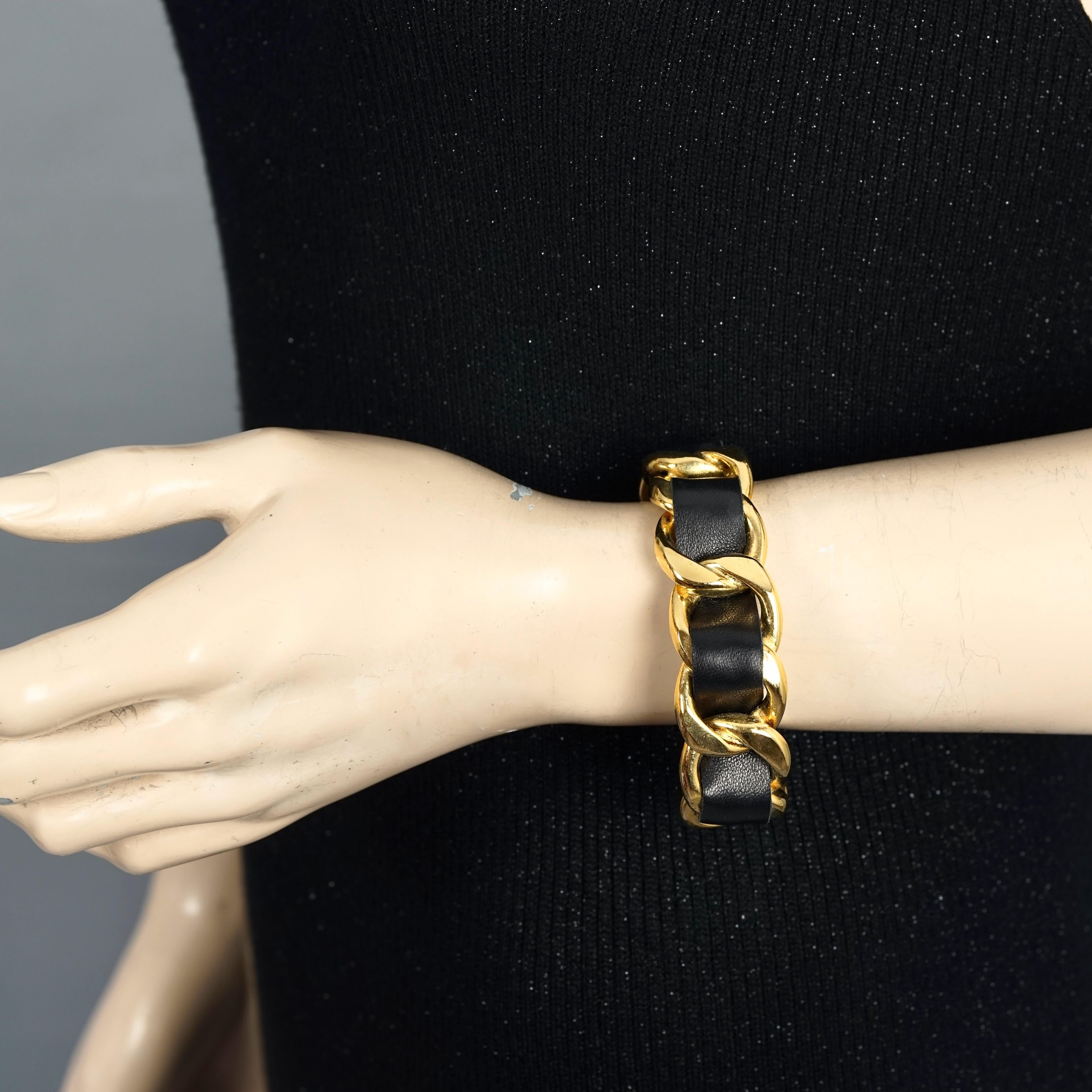 Vintage CHANEL Classic Gold Chain and Leather Cuff Bracelet

Measurements:
Height: 0.90 inch (2.3 cm)
Inside Circumference: 7.20 inches (18.3 cm) opening included

Features:
- 100% Authentic CHANEL.
- Rigid and chunky chain and black leather.
-
