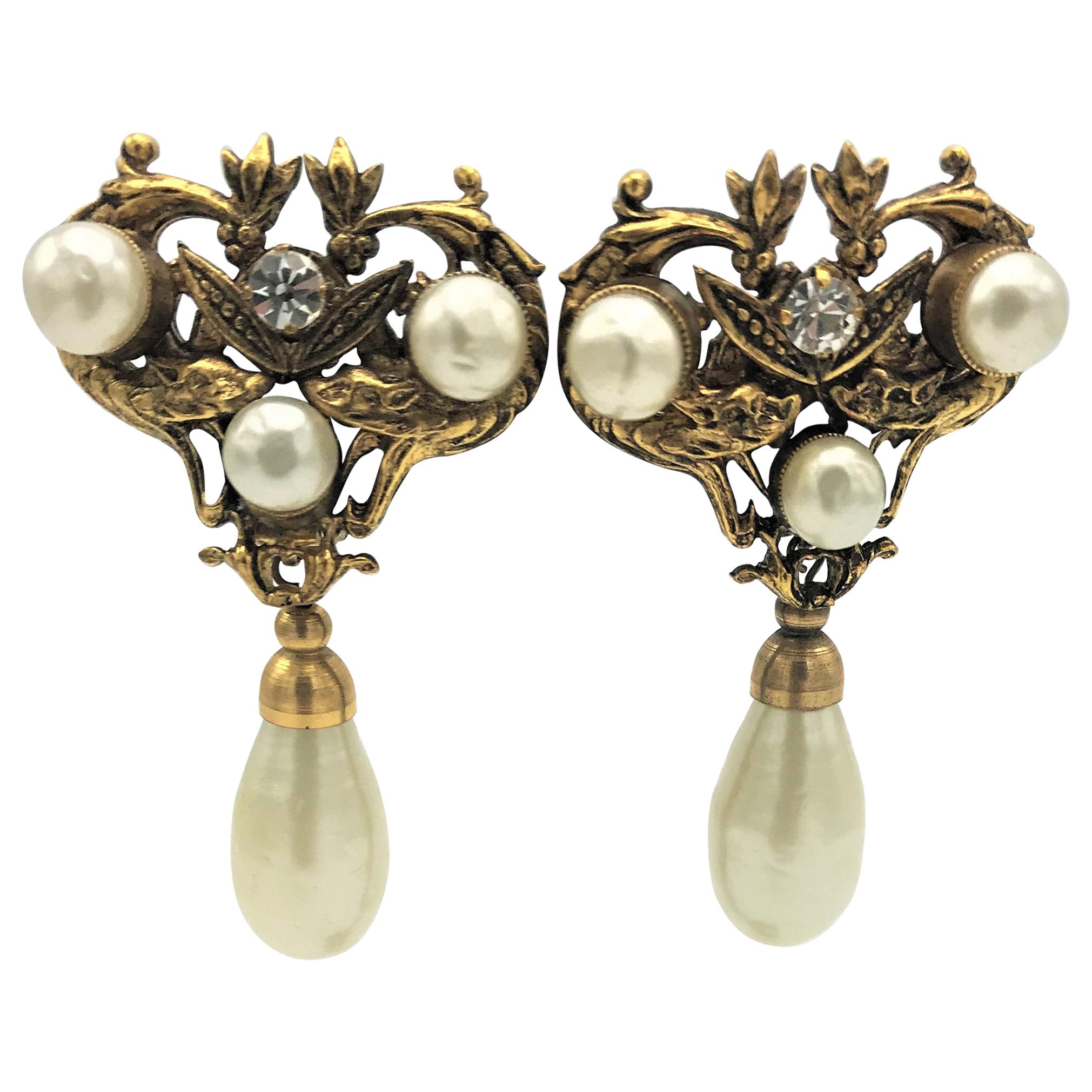 A very unusual Chanel ear clip. On the upper part there are 3 faux pearls entwined by 2 snakes, in the middle a rhinestone with 2 leaves, typical for this work from the 1983 years. Attached a beautiful, large drop-shaped faux