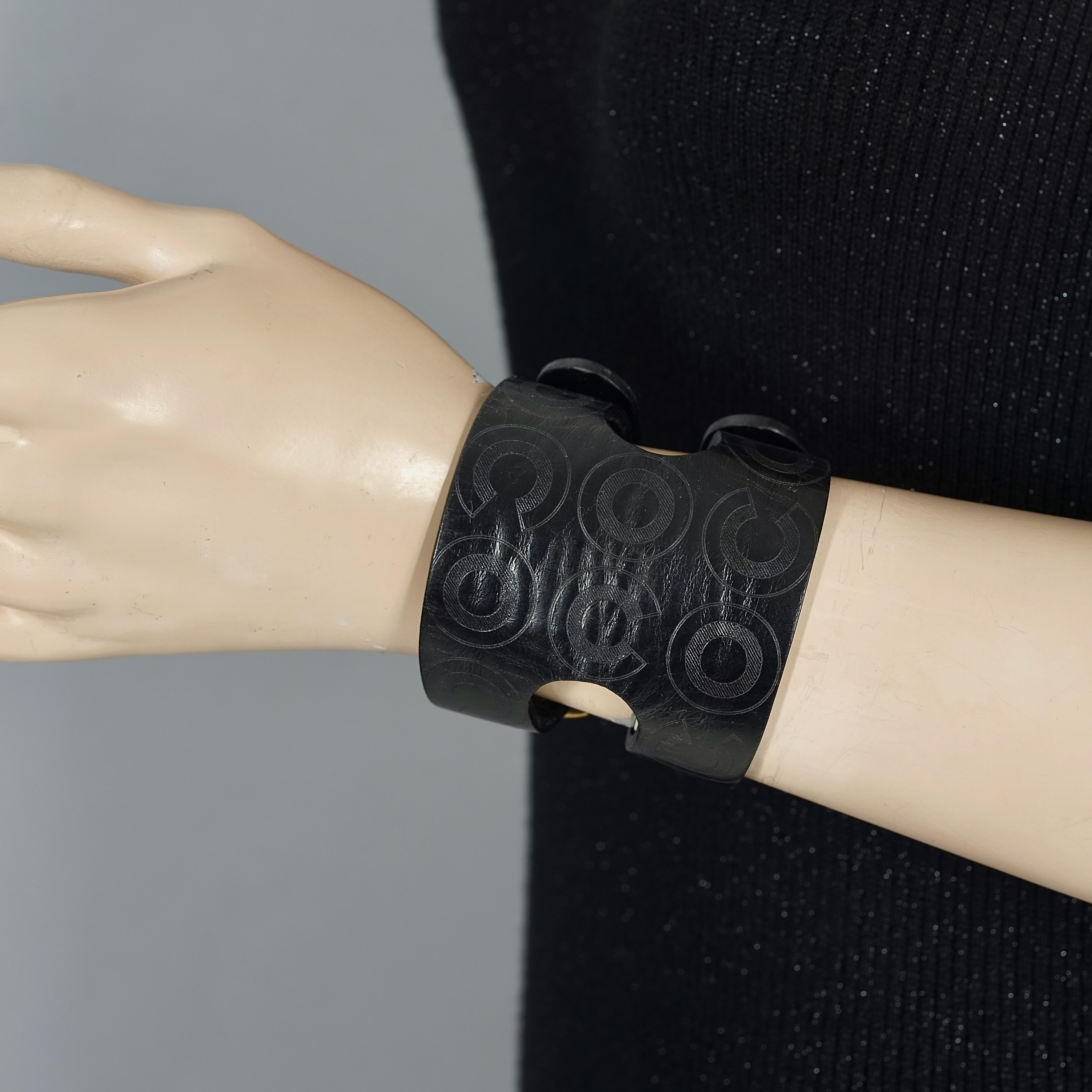 
Vintage CHANEL Coco Black Leather Buckle Cuff Bracelet

Measurements:
Height: 2.56 inches (6.5 cm)
Circumference: 6.50 inches to 8.27 inches (16.5 cm to 21 cm)

Features:
- 100% Authentic CHANEL.
- Wide black leather with engraved COCO on the