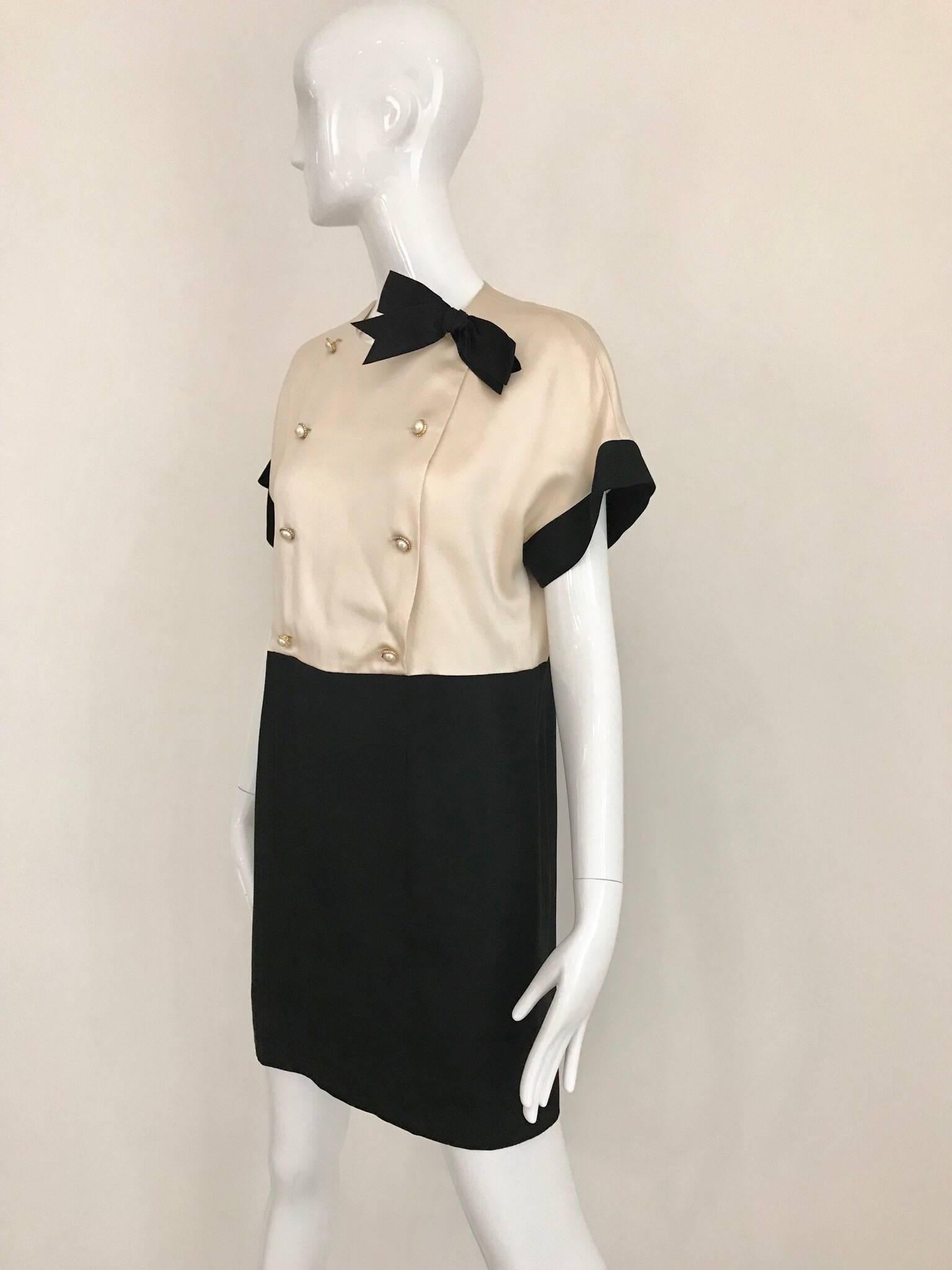 1980s Classic CHANEL Creme and Black silk charmeuse cocktail dress. Dress has gold pearl buttons and black satin bow.  Size: Small - Medium. 2/4/6
Bust: 39 