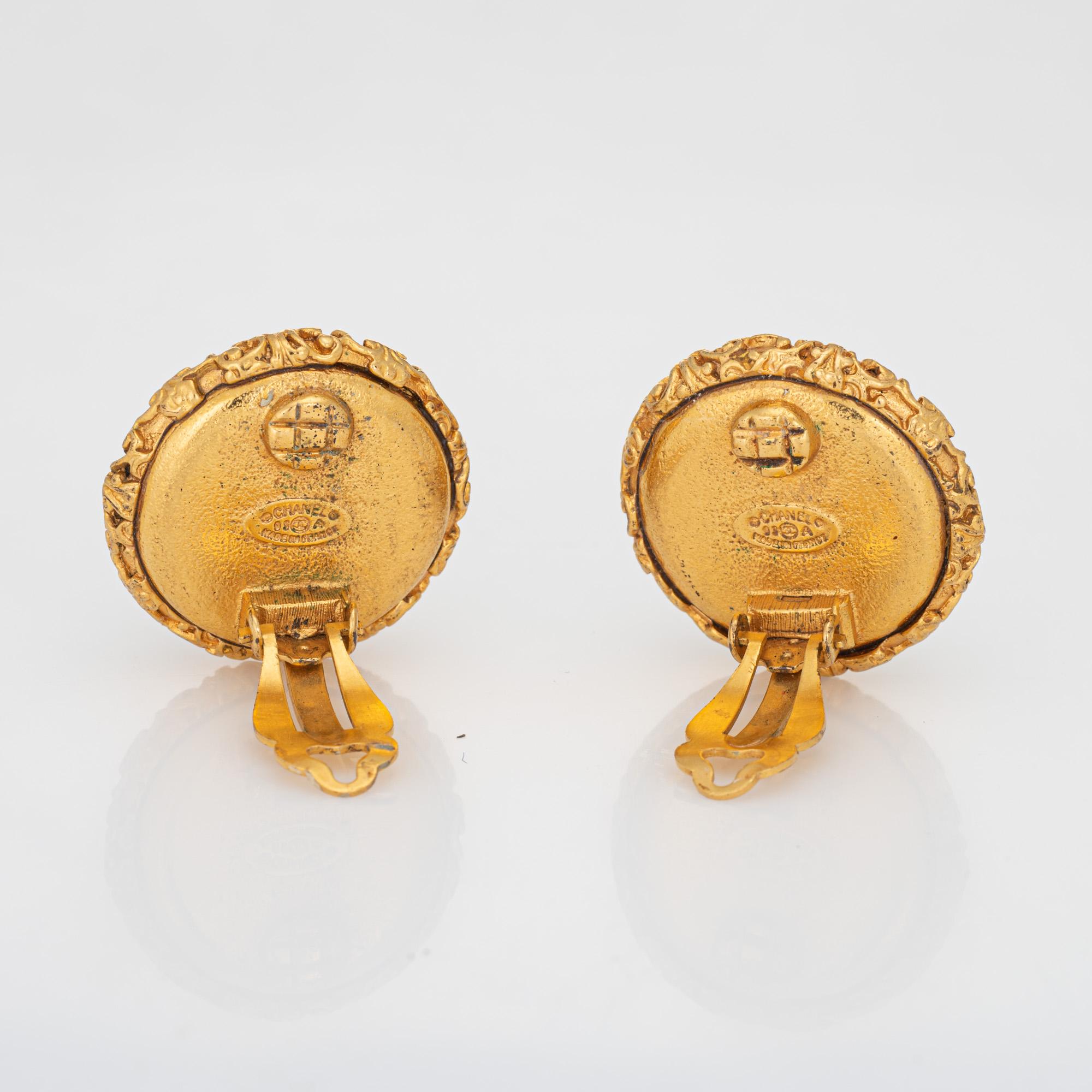 Vintage Chanel large round clip on CC logo nugget earrings crafted in yellow gold tone (circa 2003).

The earrings feature the CC logo to the center with ornate textured nugget detail and faux pearls to the base. The earrings are fitted with clip on