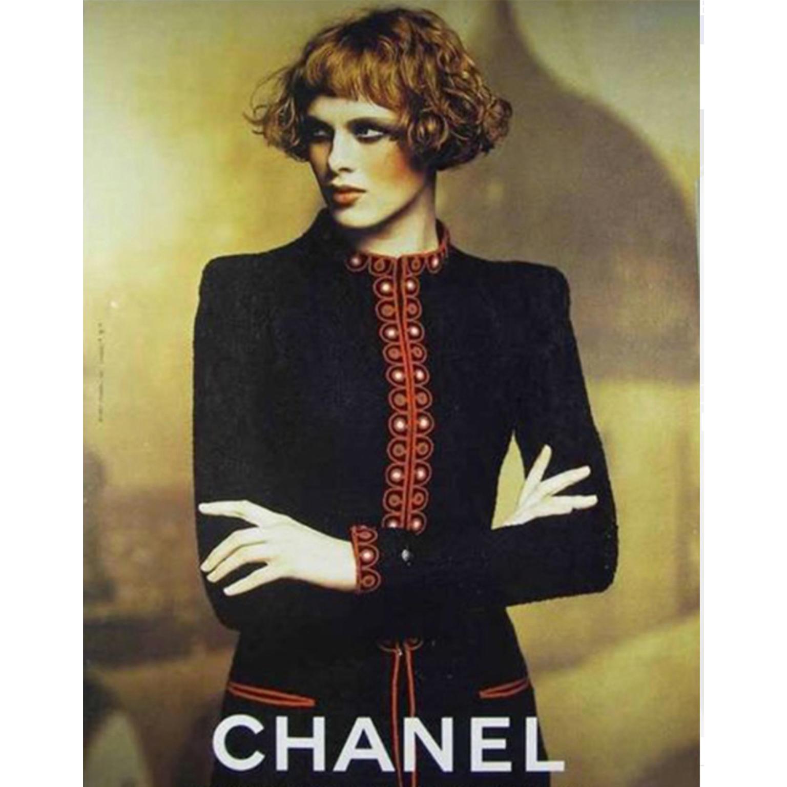 We are obsessed with this vintage 1997 Chanel navy bouclé wool blend jacket with red embroidered trim and a matching pleated mini skirt. This iconic suit was designed by Karl Lagerfeld for the Fall Winter 1997 Chanel collection. If you don't wear