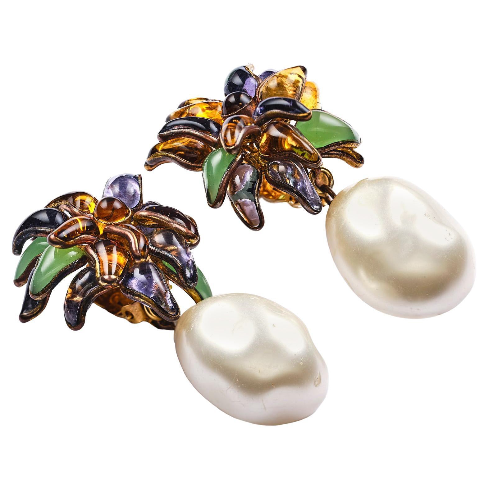 An extraordinary ear clip designed by Victoire de Castellane for Chanel in 1984. The flower is handmade of pured liquid glass with 17 small leaves in four different colors: purple, mint, yellow and brown. On the flower hangs a fantastic and huge