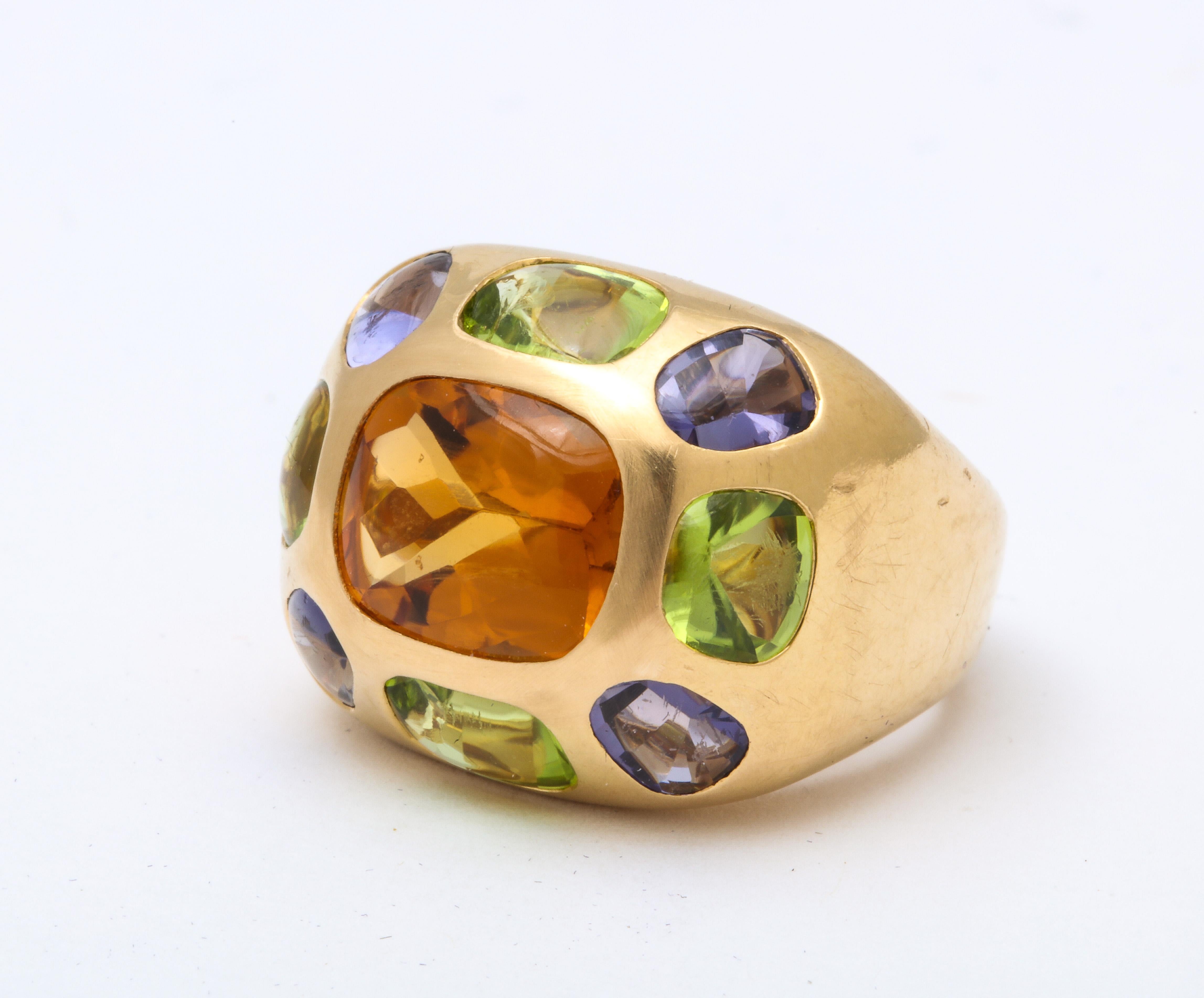 This fabulous vintage Chanel ring  has a  citrine center stone with smaller semi precious stones including peridot and iolite, all invisibly se,t in a classic mounting of 18 K gold.  It has authentic Chanel Paris hallmarks  and was  made in