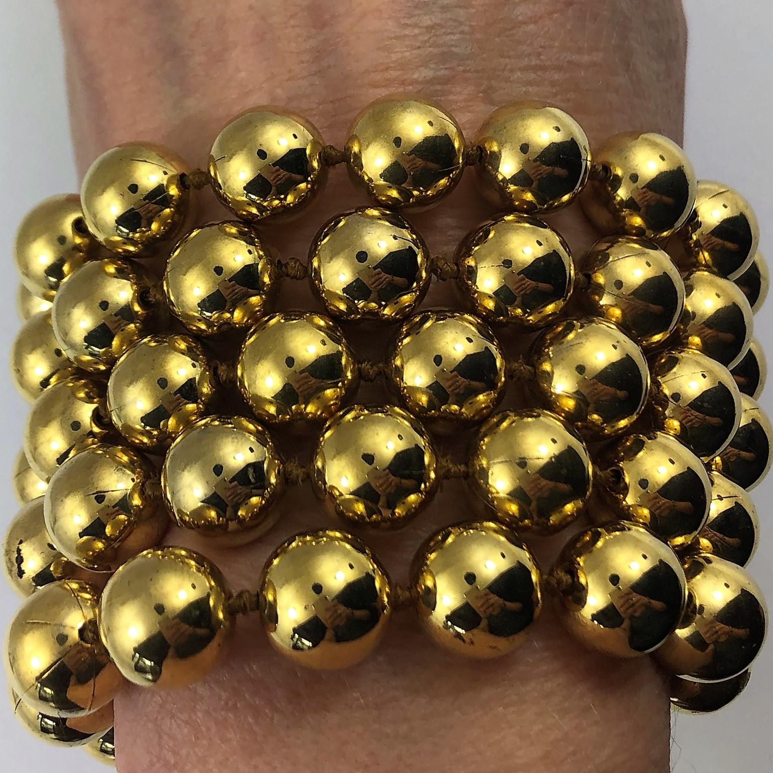 This over the top, Vintage Chanel 5 strand, 10mm gold tone bead bracelet
measures 2 1/4 inches wide. The adjustable clasp in the back allows for various
lengths, ranging tom 7 to 8 1/2 inches. Part of Chanel's Season 27 from 1990. 
Marked Chanel 2