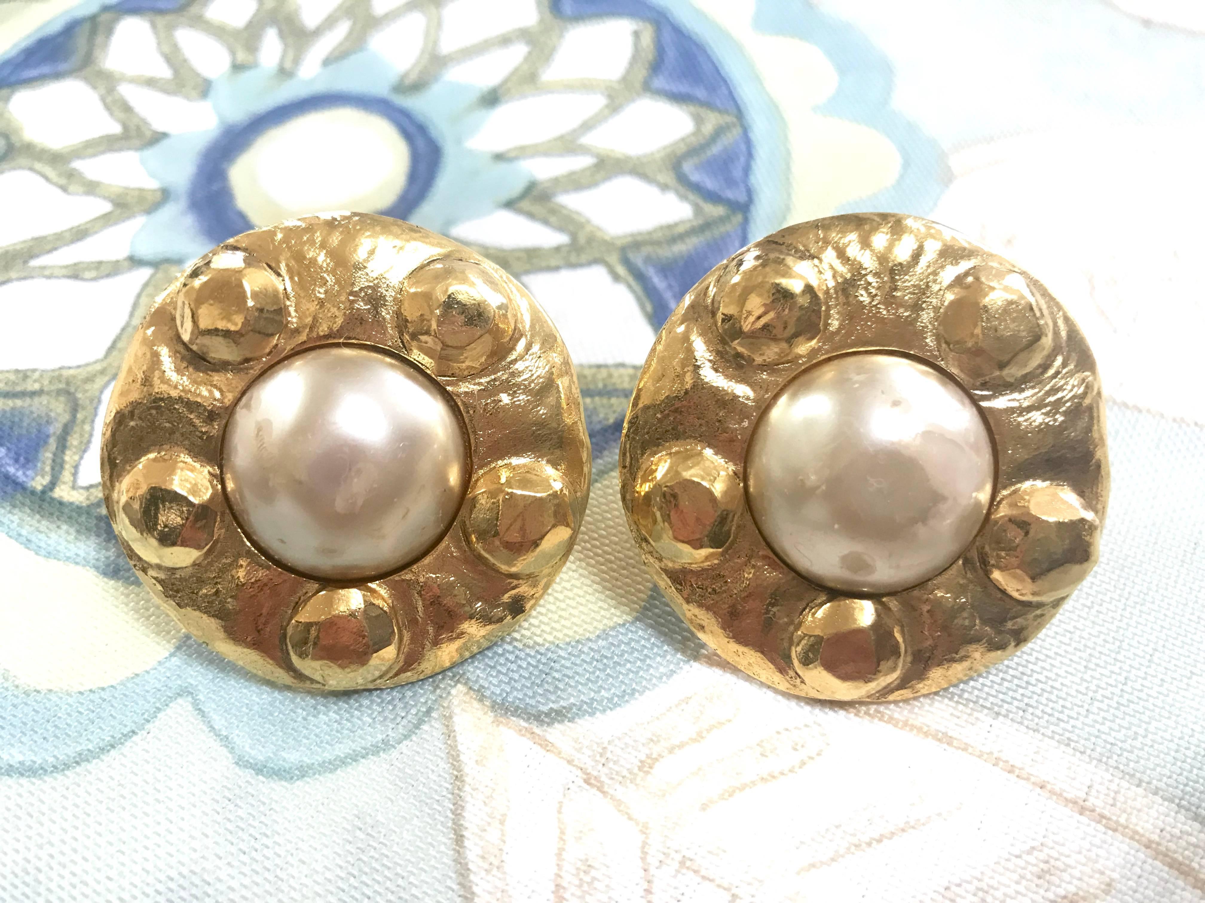 1990s. Vintage CHANEL gold tone large round earrings with faux pearl. Classic jewelry.

Introducing a beautiful pair of classic round design vintage Chanel earrings that feature faux pearl at center.                    

The large earrings will make