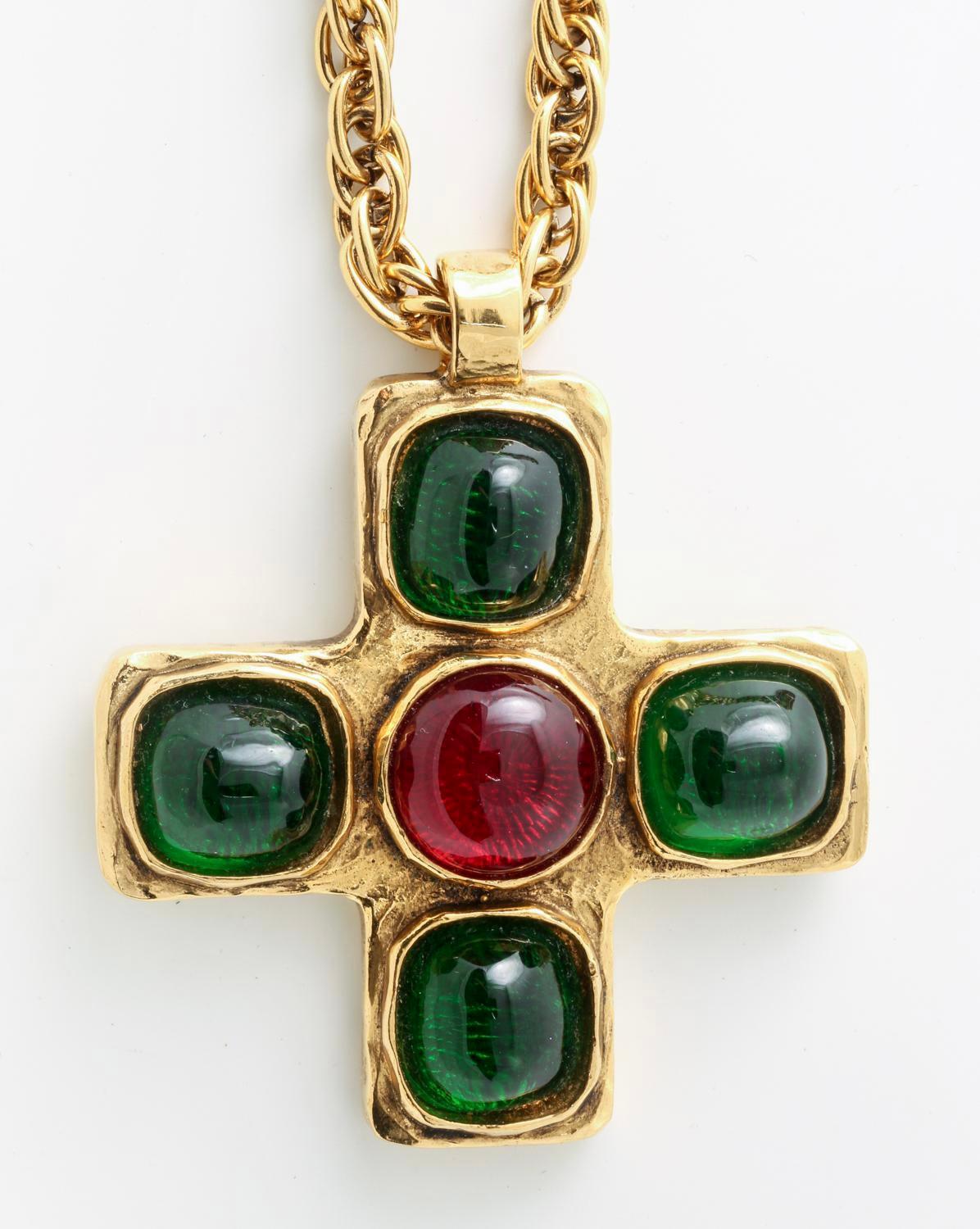 Vintage Chanel Gripoix Glass Cross Necklace, 1982. Green and red glass mounted in gold tone metal; the chain marked 'Chanel 1982' and 'Made in France', the pendant marked 'Chanel Depose' and numbered.
This piece is a real fashion statement. The