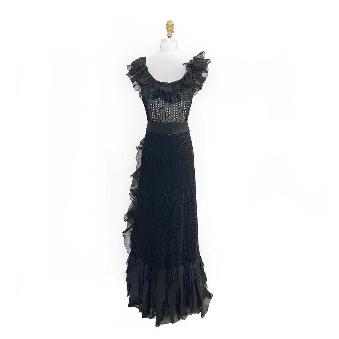Vintage haute couture eyelet ruffle gown by Chanel
Made in France
1979
Black 
Decorative eyelets throughout fabric
Ribbon bow belt 
Ruffle shoulder straps 
Ruffle detail continues asymmetrically down front wrap seam
Multi-hook closure at bust  
Side