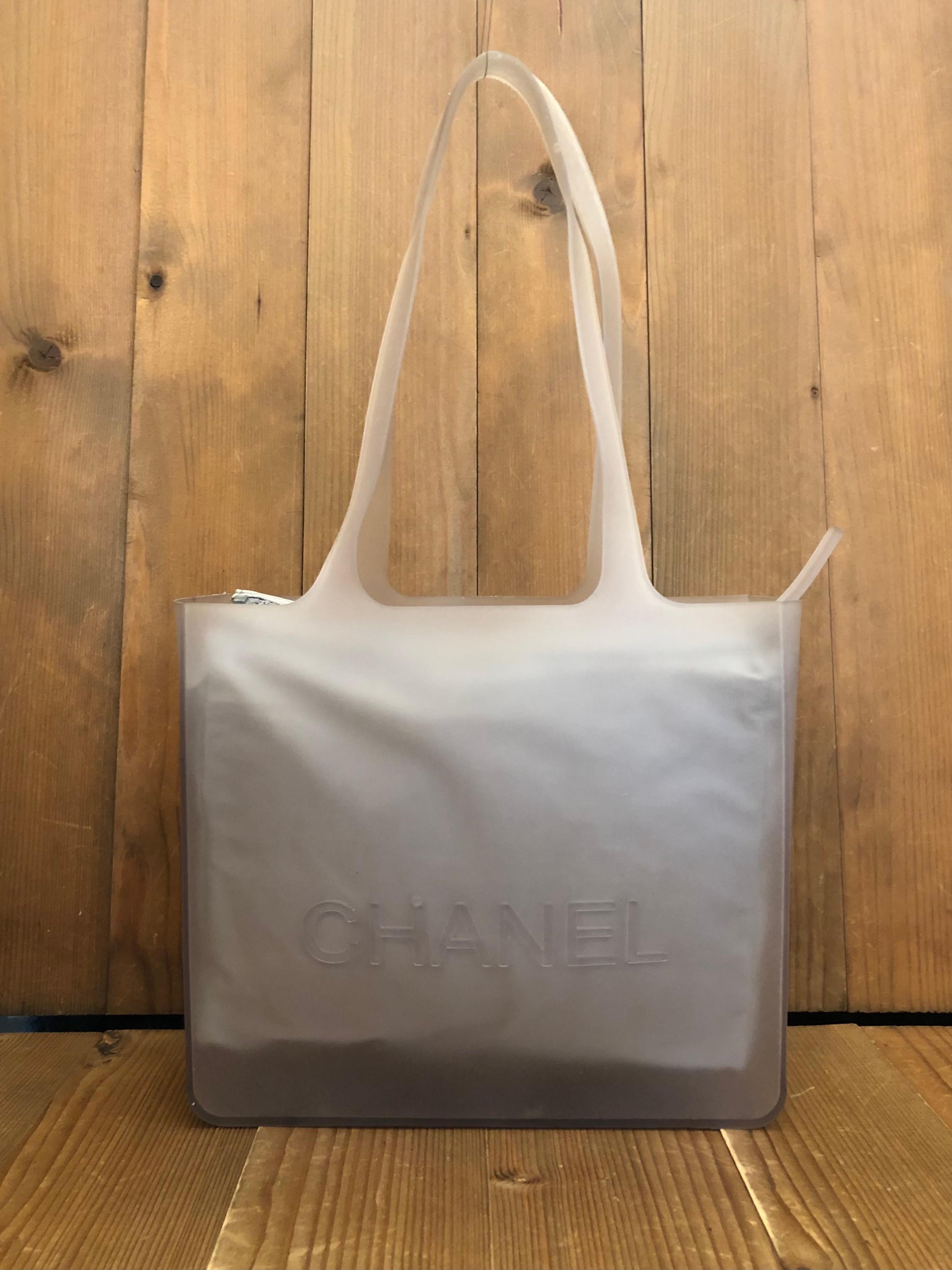 Thai CHANEL translucent tote is crafted of silicone in neutral featuring a fabric zippered pouch in silvery gray. Made in France. Measures approximately 9.75 x 8.5 x 2.75 inches Handle Drop 9 inches. Comes with original zippered pouch insert. Serial
