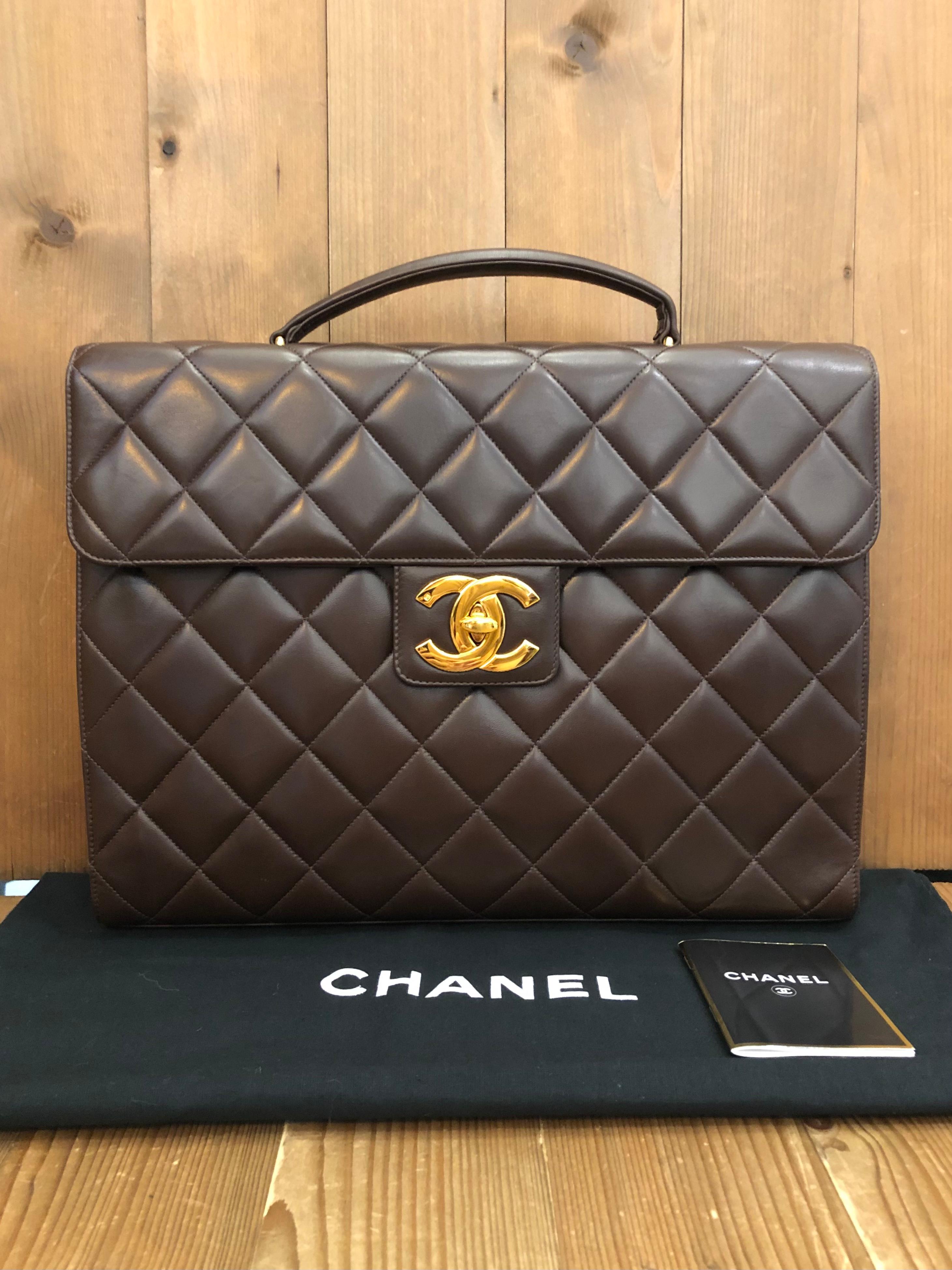 This vintage CHANEL jumbo Logo briefcase is crafted of lambskin leather in chocolate brown and gold toned hardware. Frontal oversized 24K gold plated CC turnlock opens to a brown leather interior featuring patch and zippered pockets. This briefcase