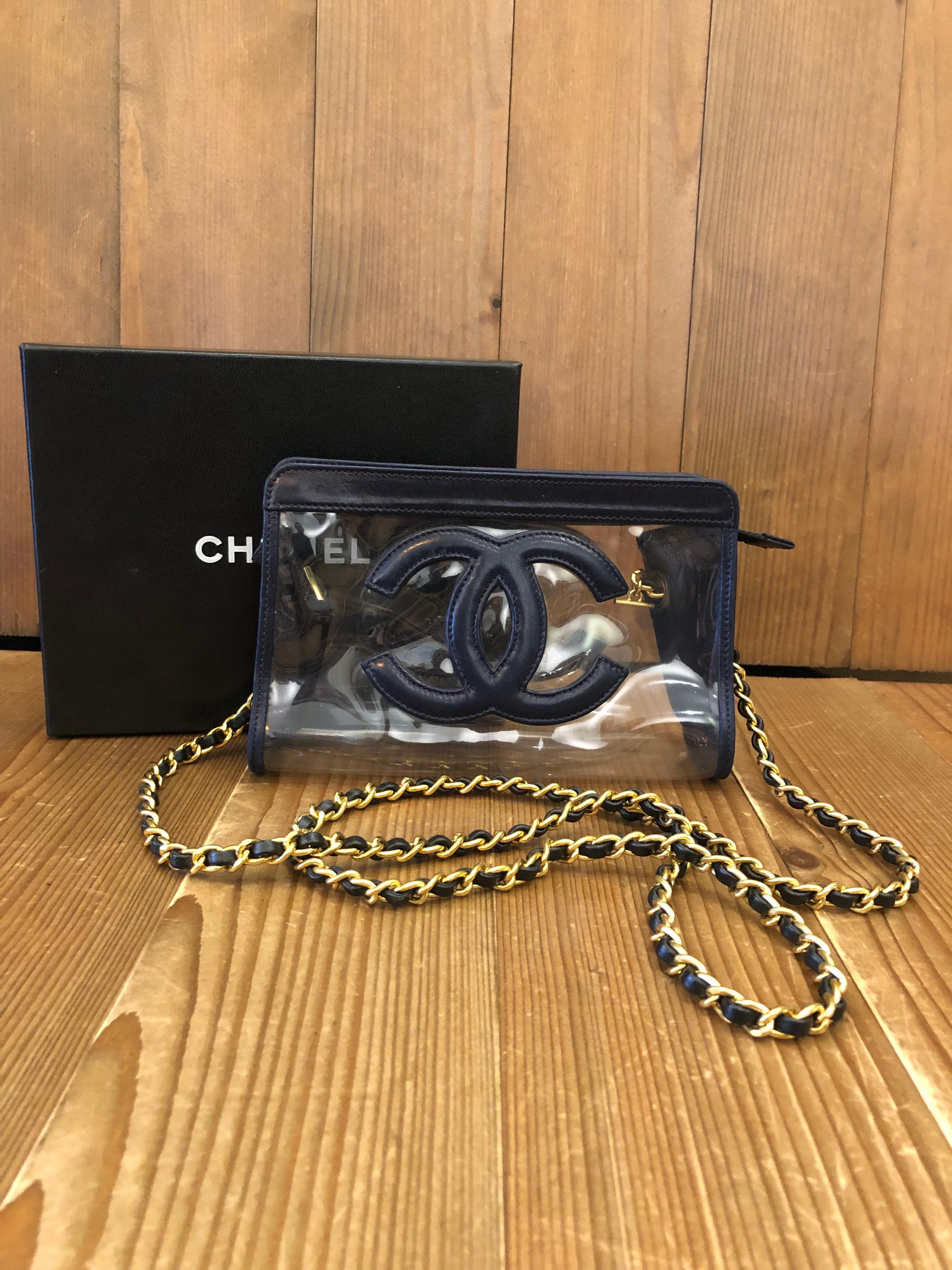 This vintage CHANEL pouch bag is crafted of lambskin leather in navy and transparent vinyl. Top zipper closure opens to an unlined interior. 3xxxxxx series (1994 - 1996) made in Italy. Measures approximately 7 x 4 x 2 inches. Third party eyelets are