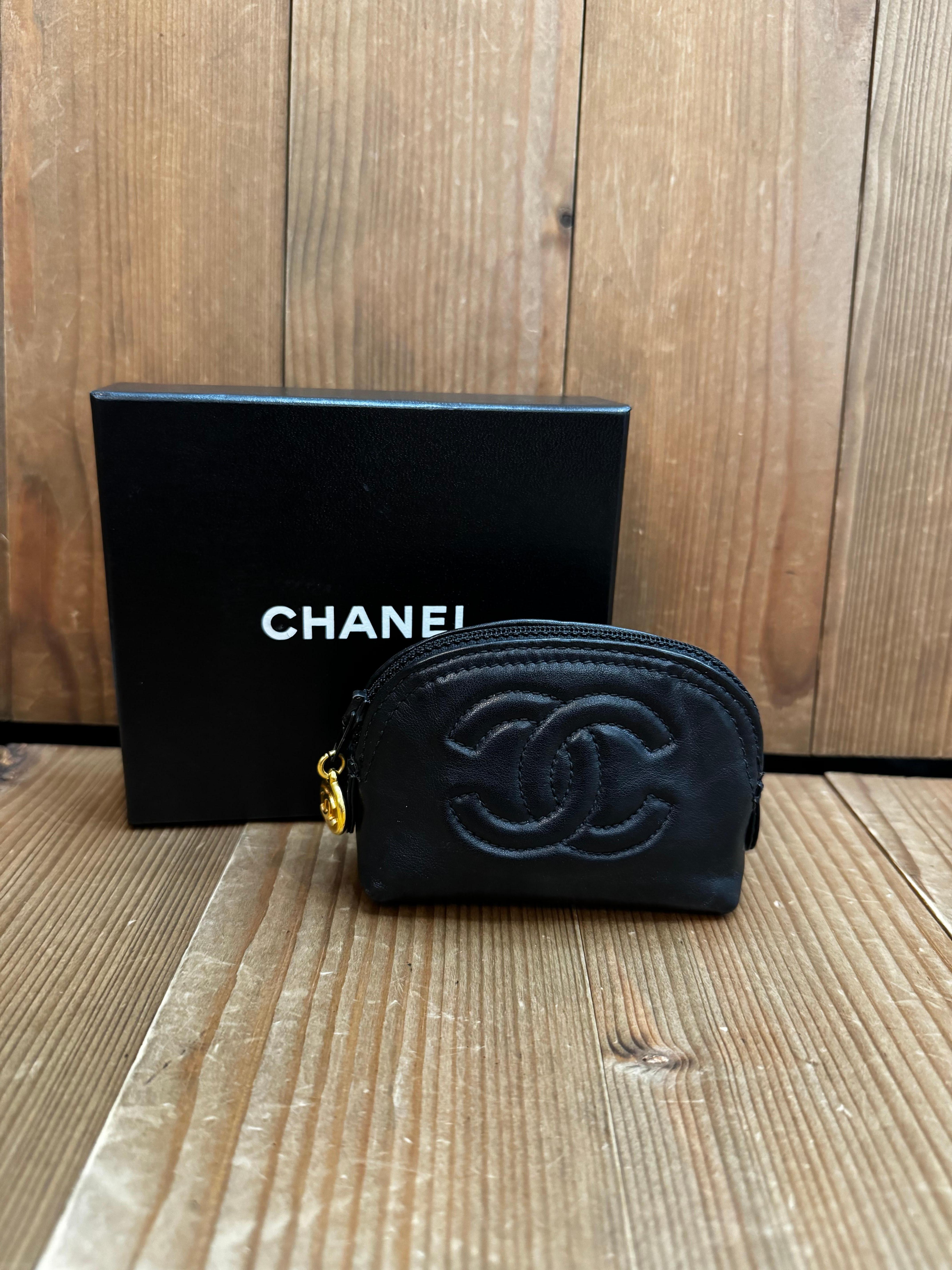 This vintage CHANEL mini pouch bag is crafted of lambskin leather in black featuring gold toned hardware. Top zipper closure opens to a beige lamskin leather interior. Measures approximately 4 x 3 x 1.5 inches. Made in Italy 3xxxxxx holo series.