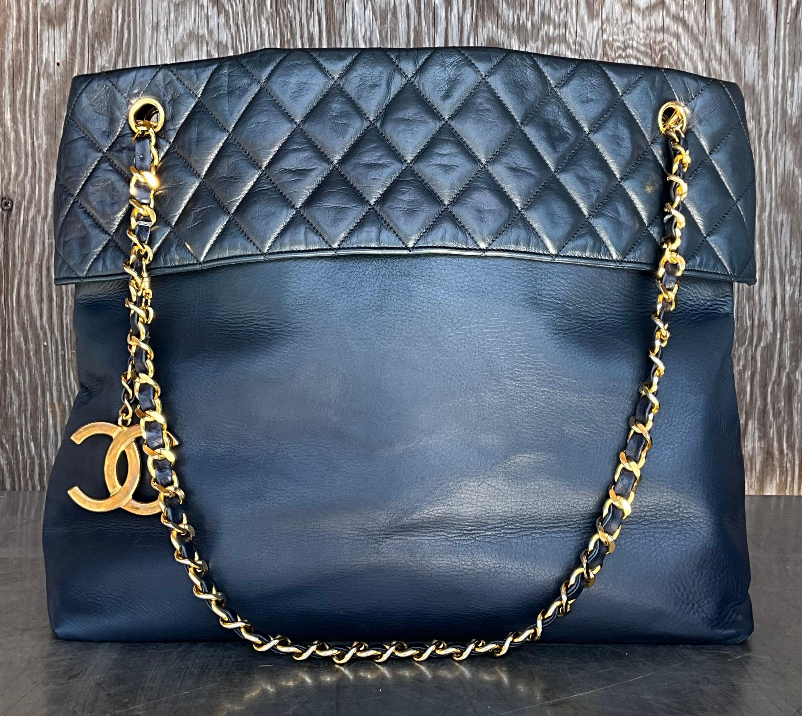 Le sac à bandoulière vintage en cuir d'agneau matelassé de Chanel en Navy est l'incarnation du luxe, de l'élégance intemporelle et de l'artisanat. Le cuir d'agneau de Chanel, connu pour sa texture douce et souple, est un élément clé qui distingue ce