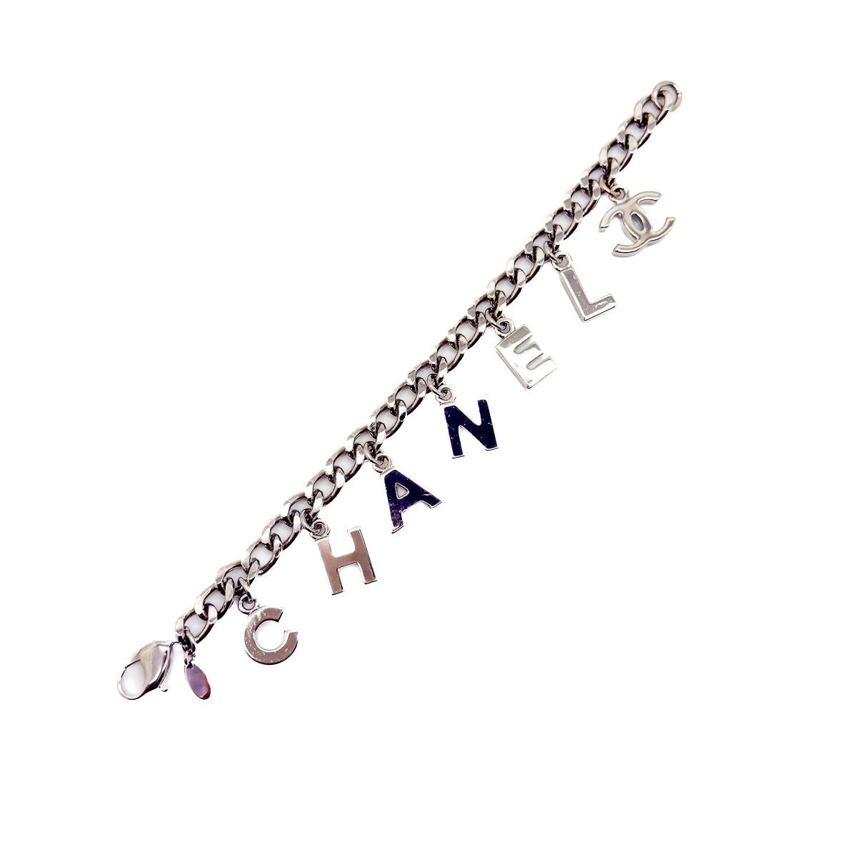 Un favoloso tesoro vintage della Maison Chanel, questo braccialetto Letter Charm del 2005 è l'epitome del cool. Realizzata in metallo rodiato, l'audace catena a maglie appiattite è ornata da charms a forma di lettera sovradimensionati che scrivono