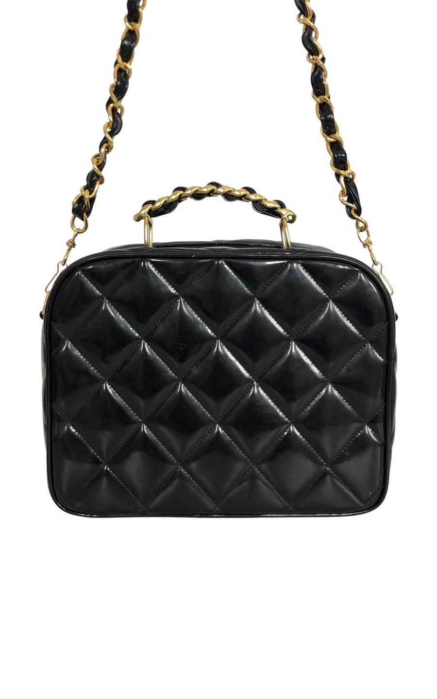 Chanel Limited Edition Crossbody bag in black Enamel (patent) leather. The bag has gold colored hardware. The bag opens with a zipper. The black inside features one main compartment. There is one zipper pocket and one slip-in pocket inside. The bag