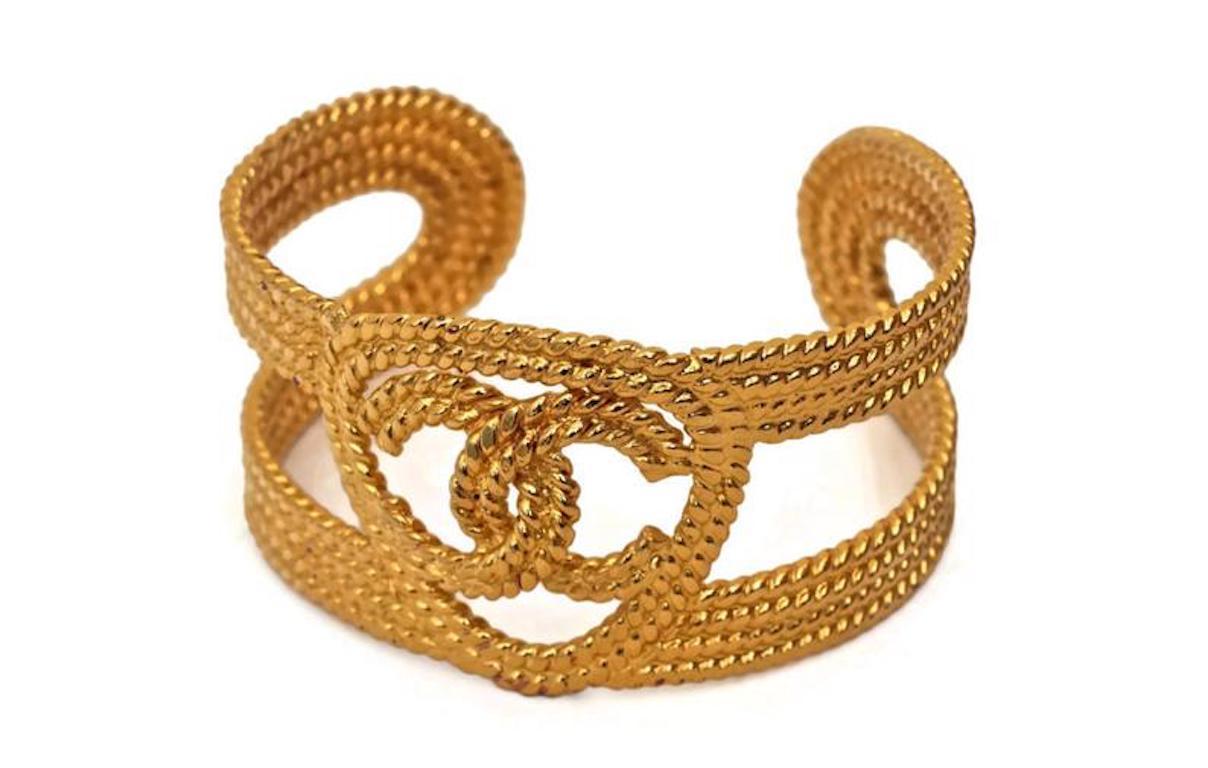 Vintage CHANEL Logo Braided Cuff Bracelet

Measurements:
Height: 1.5 inches

Features:
- 100% Authentic CHANEL.
- Braided/ rope pattern with CC logo at the center.
- Signed CHANEL 2 CC 8 Made in France inside.
- Will fit small to medium wrists.
-