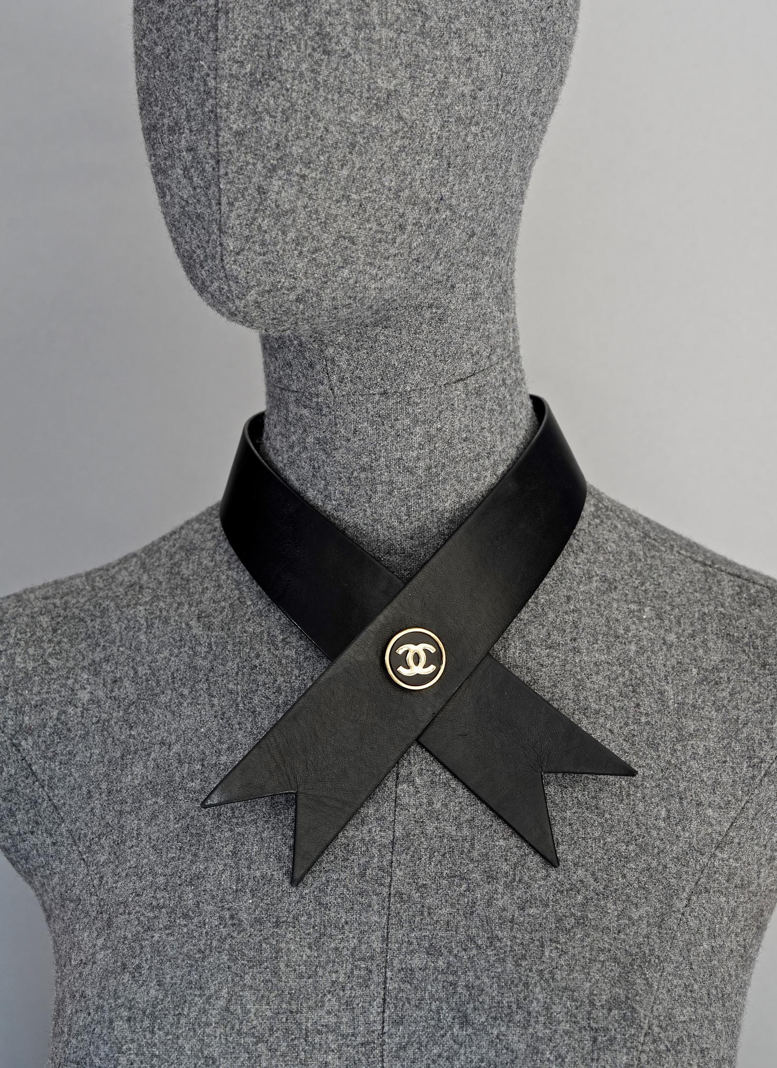 Vintage CHANEL Logo Medallion Leather Bow Choker Collar Necklace

Measurements:
Height: 1.69 inches (4.3 cm)
Wearable Length: 19.29 inches (49cm)

Features:
- 100% Authentic CHANEL.
- Iconic black leather bow strap choker/ collar.
- CC logo at the