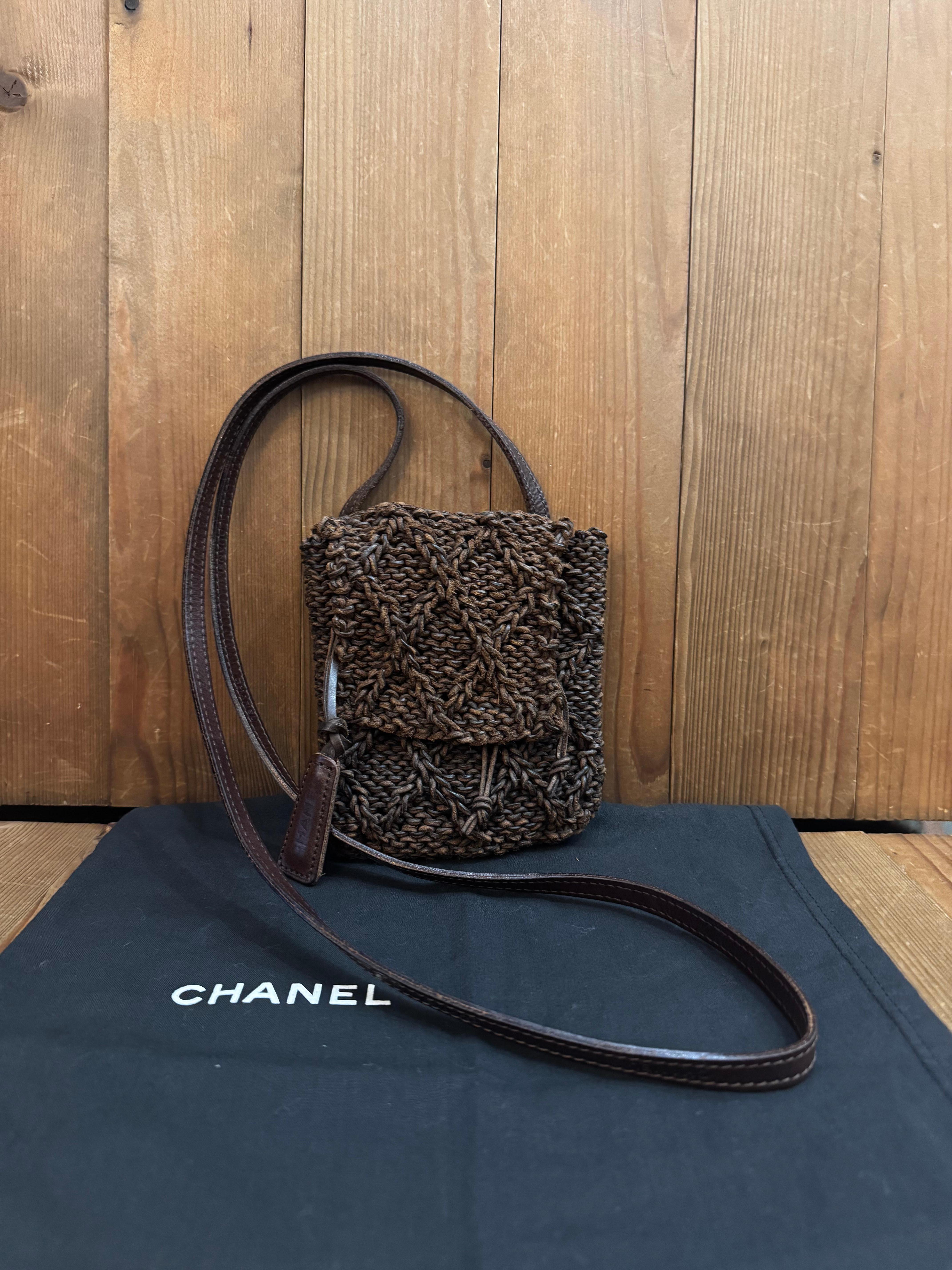 This vintage CHANEL mini crossbody bag is crafted of braided cowhide leather in chocolate brown featuring a leather crossbody strap embossed with “CHANEL”. Made in England Holo 6xxxxxx (2000-2002). Measures approximately 5.5 x 7 x 1.25 inches Strap