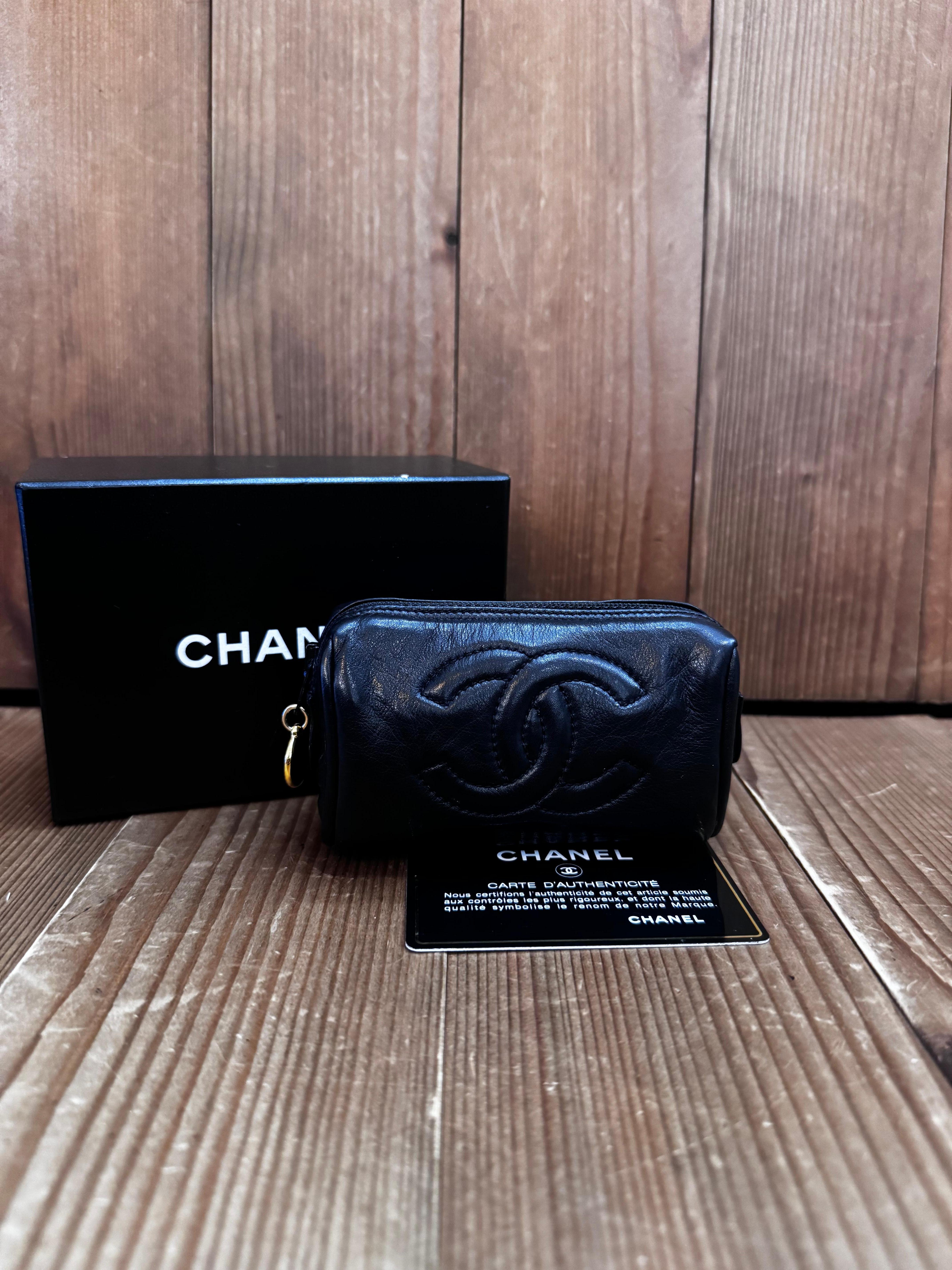 This vintage CHANEL mini pouch is crafted of calfskin leather in black featuring gold toned hardware. Top zipper closure opens to a beige lambskin interior. Measures approximately 4 x 2.5 x 1.75 inches. Made in Italy 3xxxxxx holo series. Comes with