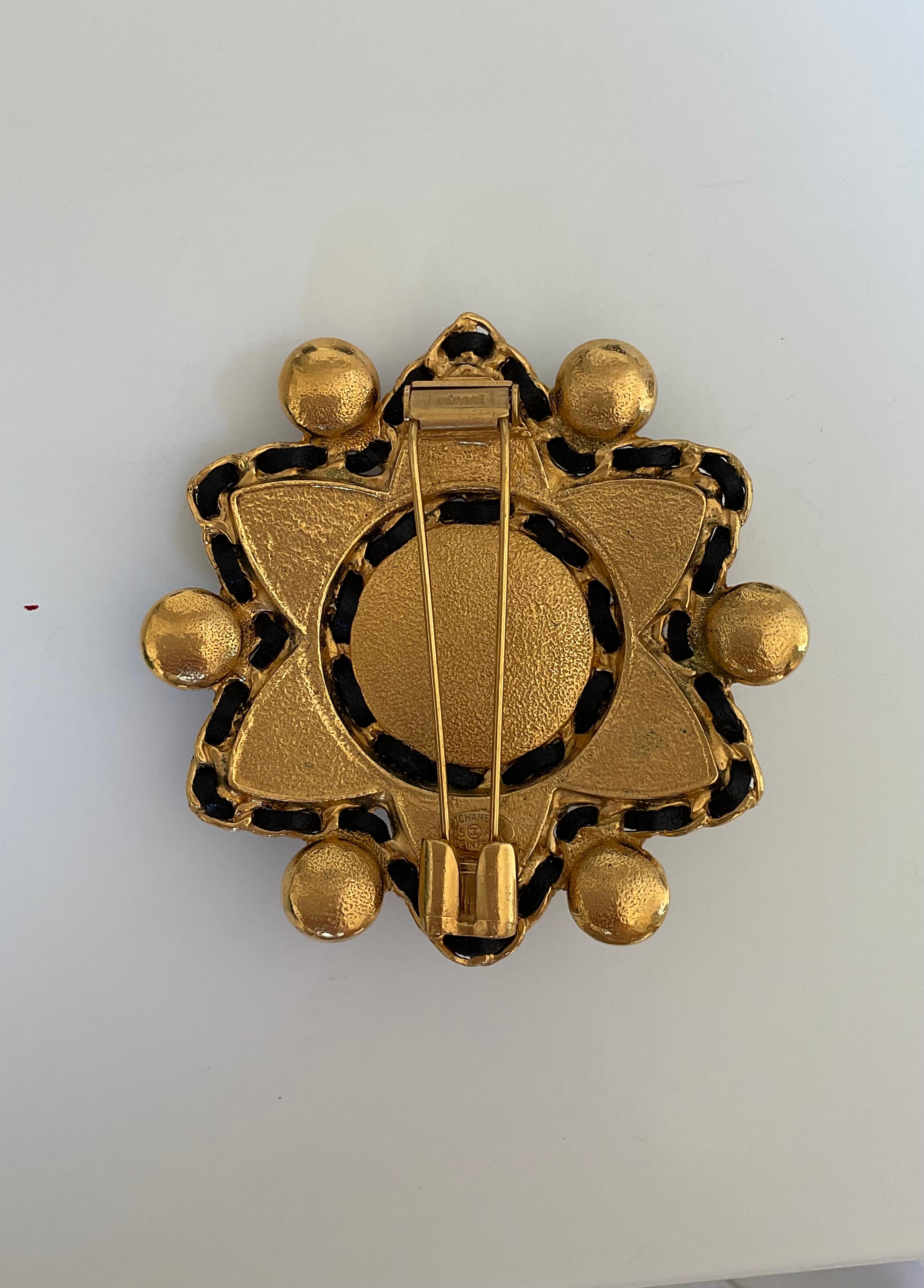 This exceptionnal Vintage CHANEL is a star shaped brooch. It is composed at its centre of a round burgundy stone in “pate de verre” made in gold plate. Surrounding the stone, there are six semi-precious stones (onyx, jasper, lapiz, etc.) in