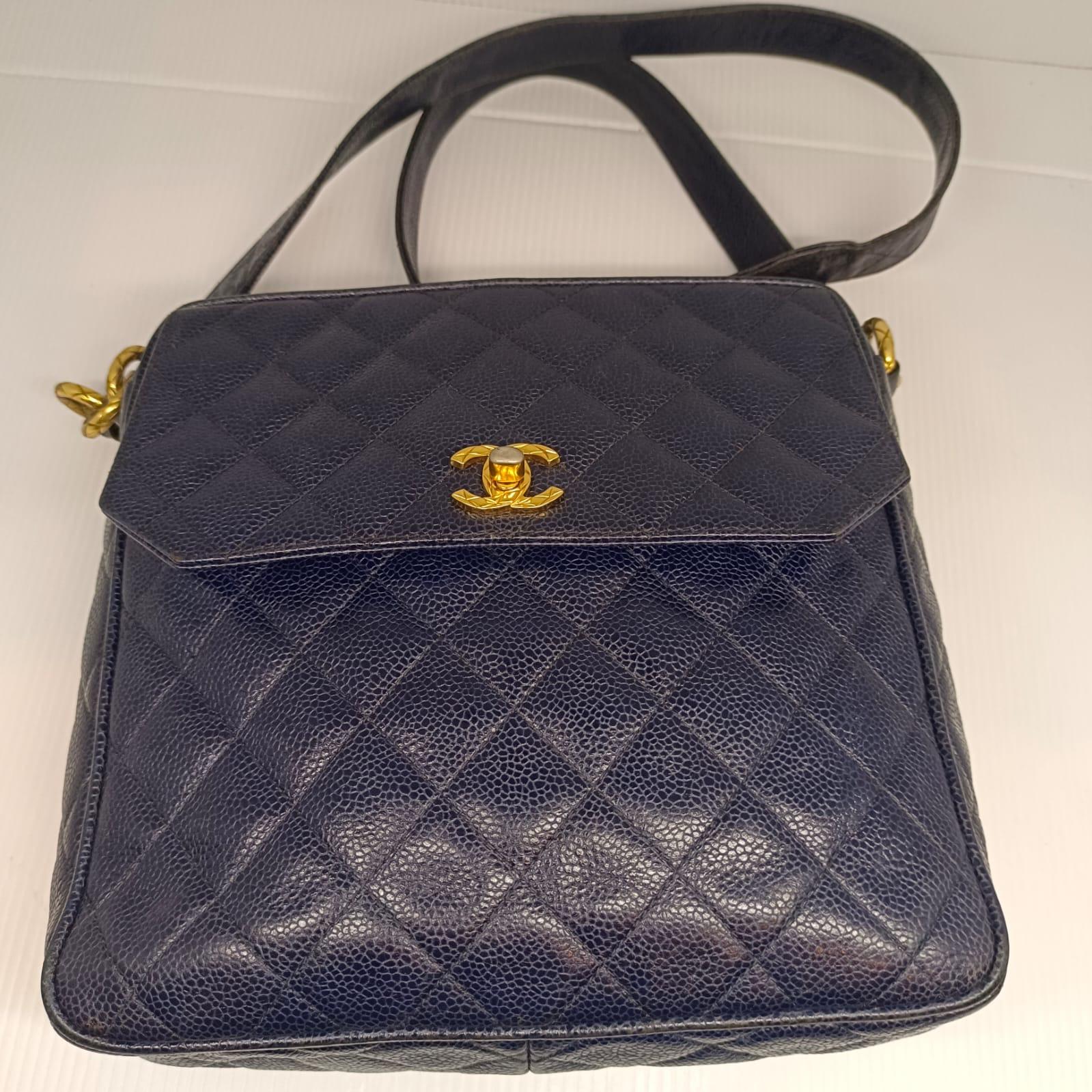 Vintage navy caviar sling bag with gold hardware. Overall in worn vintage condition, with slight lose of shape. Faint scuffing on the bag. Turn lock shows slight tarnishing as seen on pictures. Comes with its holo sticker only. Series #2.